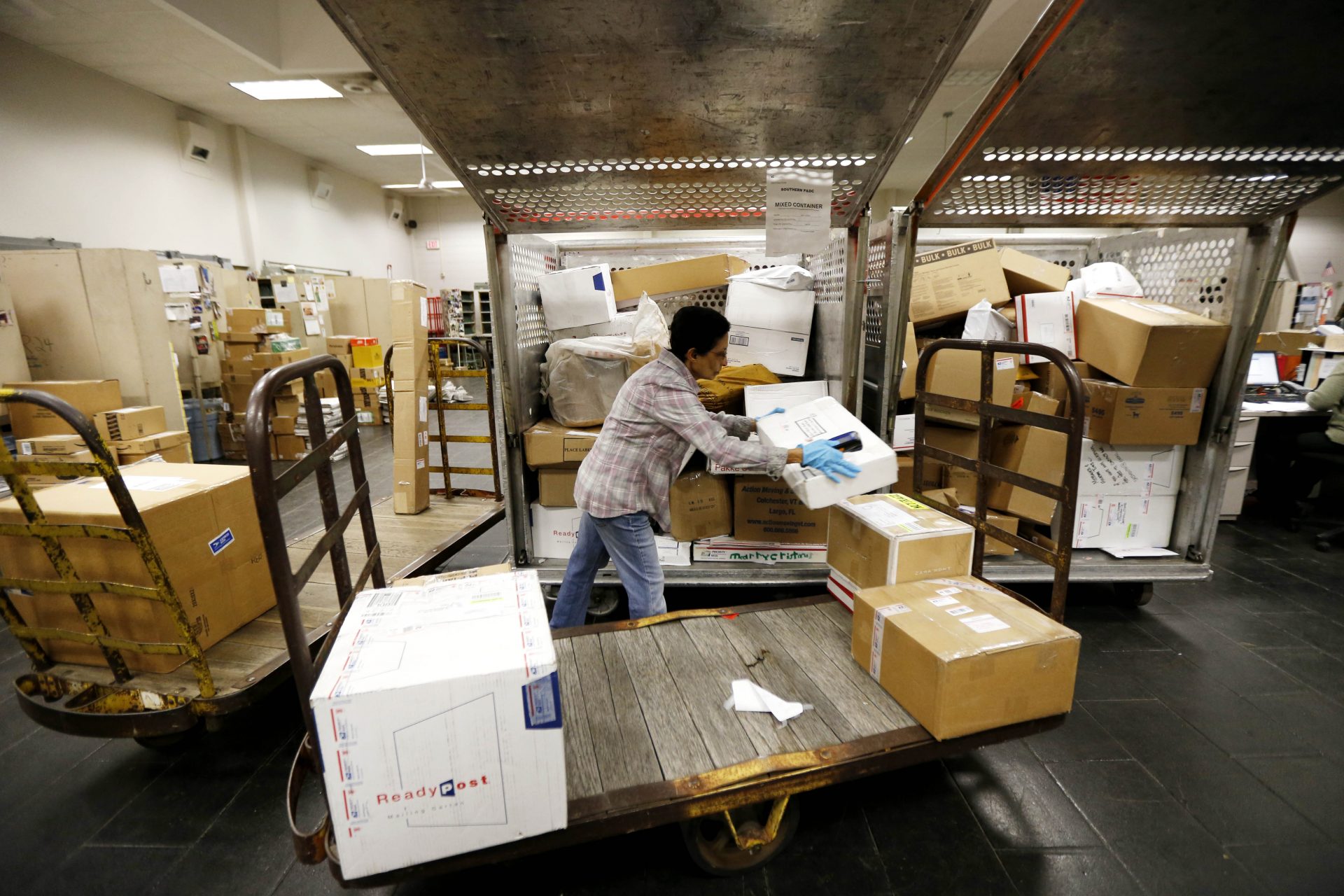 FILE PHOTO: Dee Amin sorts through packages at the Newtown post office, Friday, Dec. 21, 2012, in Newtown, Conn.