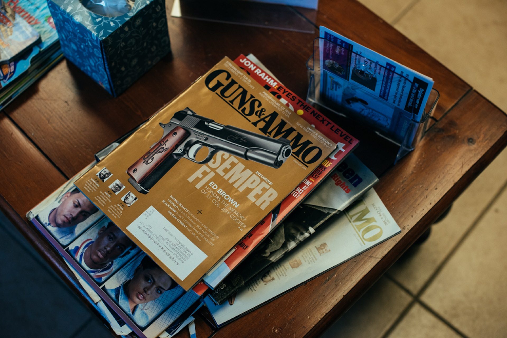A Guns & Ammo magazine sits on the coffee table at Walker's Barber Shop, not far from a copy of The New Jim Crow.