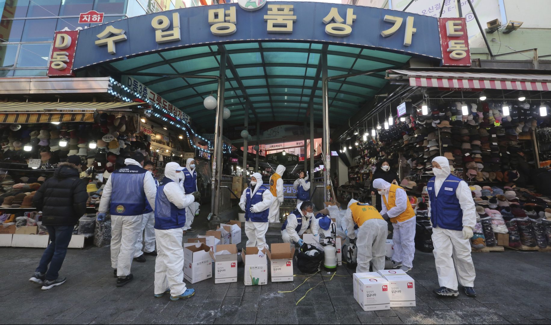 FILE PHOTO:  In this Feb. 5, 2020, file photo, workers wearing protective gears prepare to spray disinfectant as a precaution against a new coronavirus at Namdaemun Market in Seoul, South Korea. In recent days, major shopping districts and other spots in the capital Seoul popular with Chinese tourists were relatively quiet. 