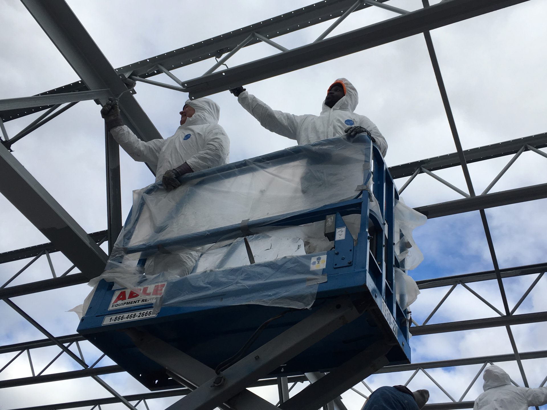 Lionel Henry (right), who works for a minority-owned contracting firm, repairs the roof of an outdoor hockey rink at Philadelphia’s Fishtown Recreation Center in December 2019. The project was part of a Philadelphia effort to expand participation of minority contractors in city-funded construction jobs.