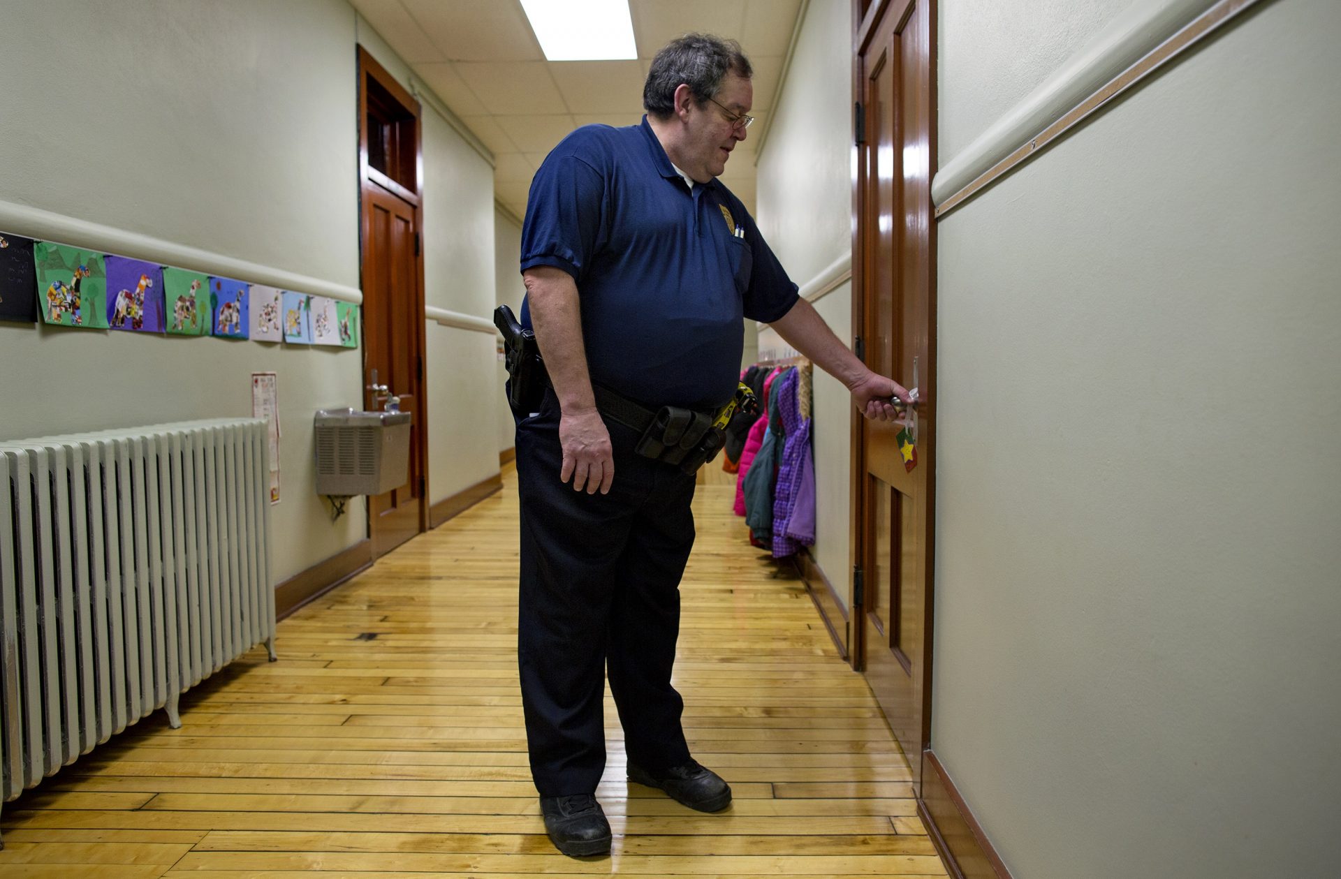 FILE - In this file photo of Jan. 14, 2013, New Washington, Ohio, Chief of Police Scott Robertson checks a teacher's door to make sure it's locked during a lockdown drill at the St. Bernard School in New Washington, Ohio, a month after the Sandy Hook Elementary School massacre in Newtown, Conn., that killed 26 people in December. Inspired by the memories of those who lost their lives, St. Bernard School's principal decided to hold lockdown drills on the 14th of each month to refine a safety plan and increase school security.