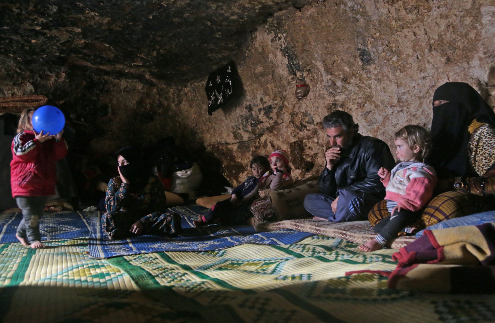 Members of a family of internally displaced Syrians sit in an underground shelter in Idlib province. The photo was taken on Sunday, February 23.