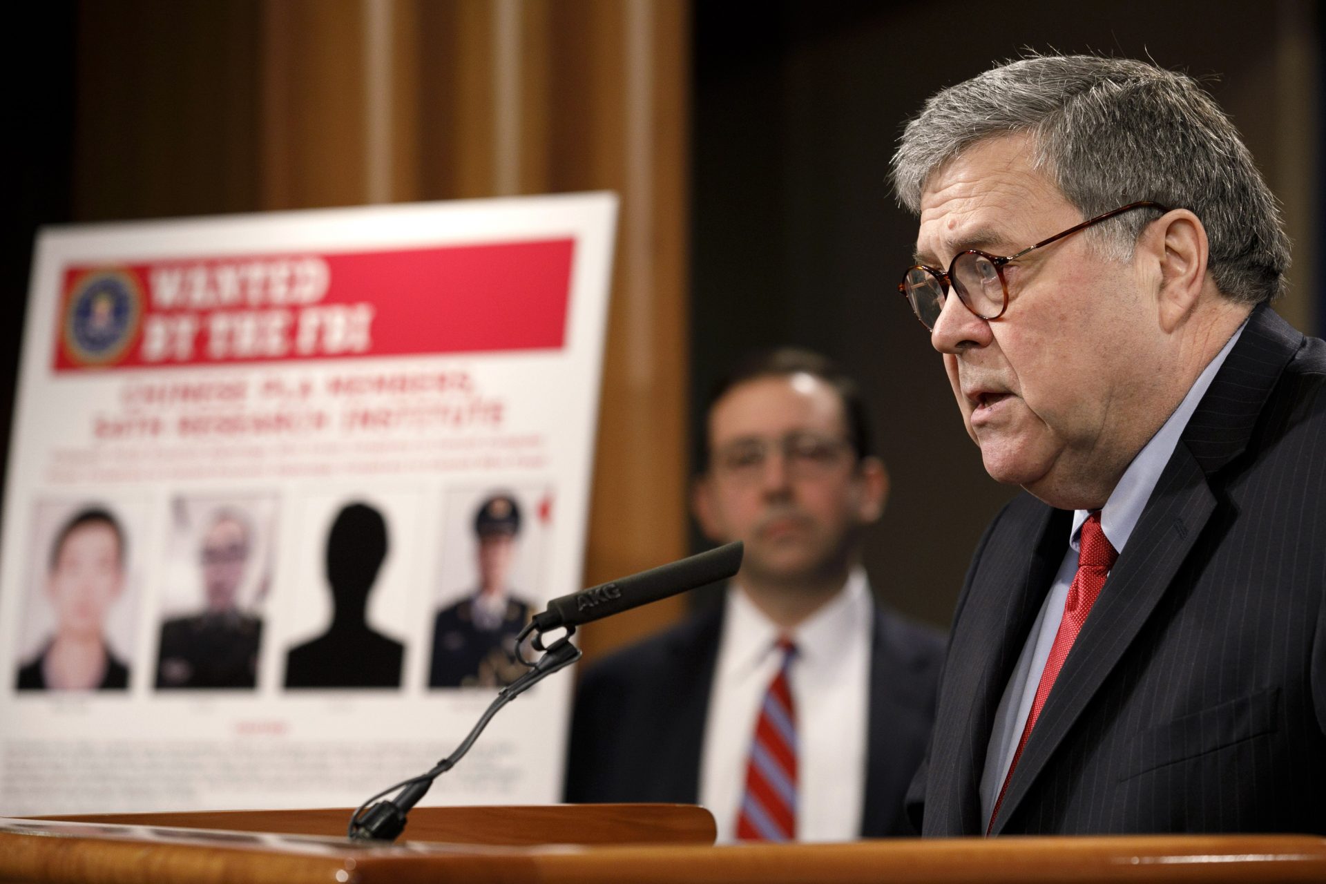Attorney General William Barr speaks during a news conference, Monday, Feb. 10, 2020, at the Justice Department in Washington, as Principal Associate Deputy Attorney General Seth Ducharm looks on. Four members of the Chinese military have been charged with breaking into the networks of the Equifax credit reporting agency and stealing the personal information of tens of millions of Americans, the Justice Department said Monday, blaming Beijing for one of the largest hacks in history.