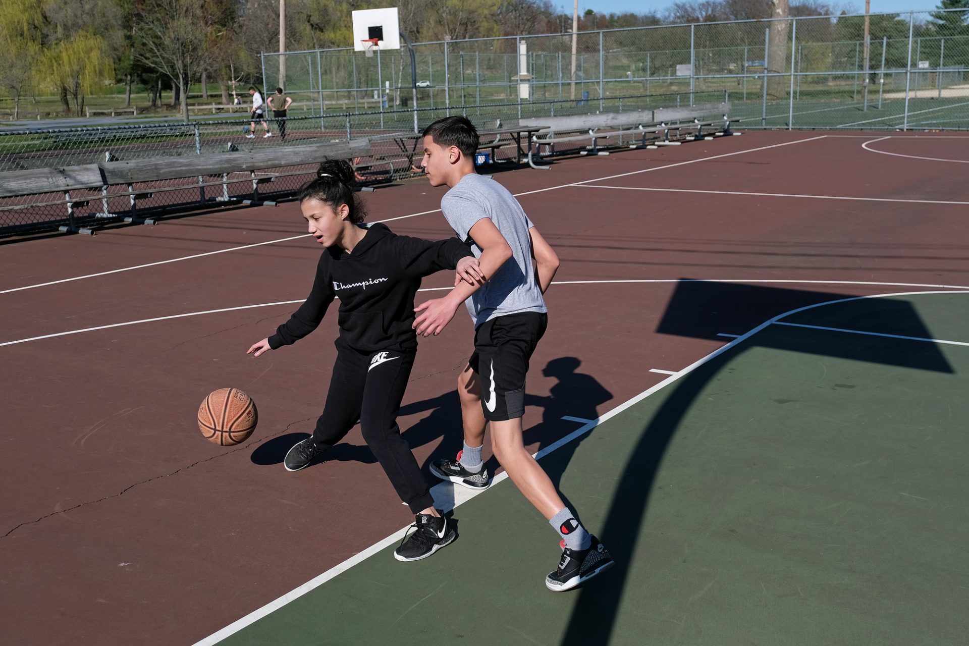Jessenia Almonte, left, of Allentown, and Gabby Ball, right, of Allentown, play basketball Mar. 21, 2020, at Cedar Beach Park in Allentown, Pennsylvania. Both are staying home as schools are closed, but they enjoy playing basketball and still want to come out to play.