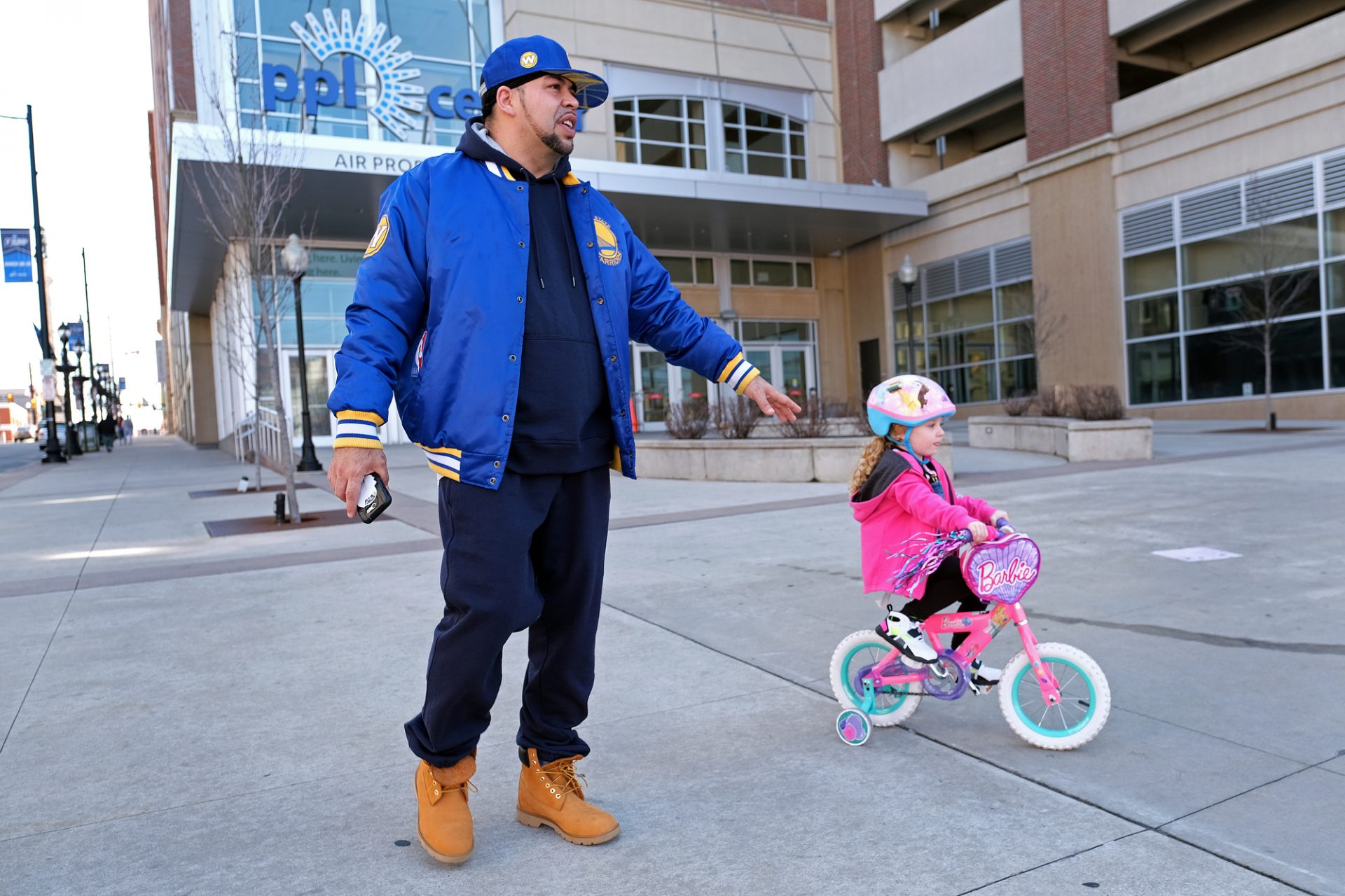 Edward Zayas, Jr., of Allentown, walks with his stepdaughter Avery Green, 4, as she rides her bike near the PPL Center in Allentown. Zayas is a chef at a bistro and has been working a lot to accommodate the increased demand for takeout and delivery orders. "We just had to get out," he said.