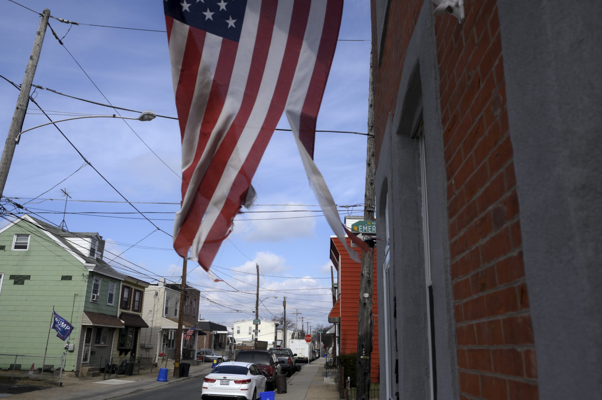 A torn American flag waves on a residential street in Bridesburg.