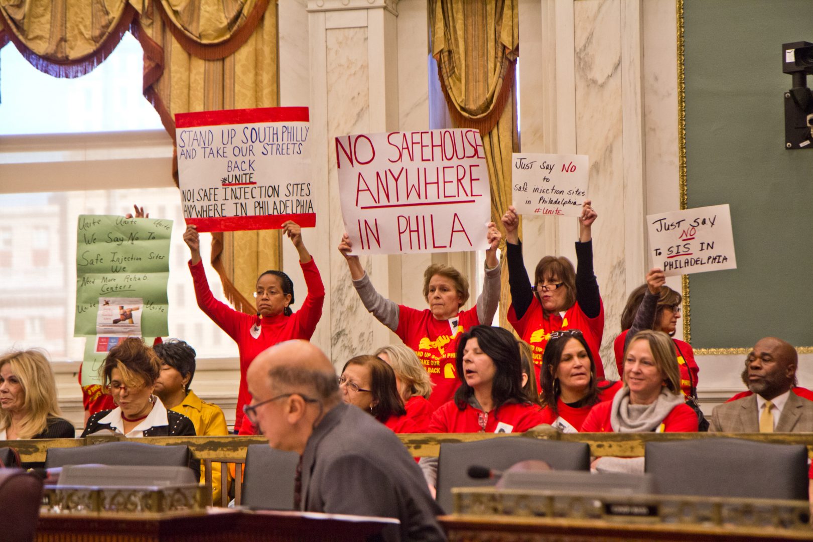 A coalition of South Philadelphia residents cheer opponents of safe injections sites at a hearing in city council Monday.