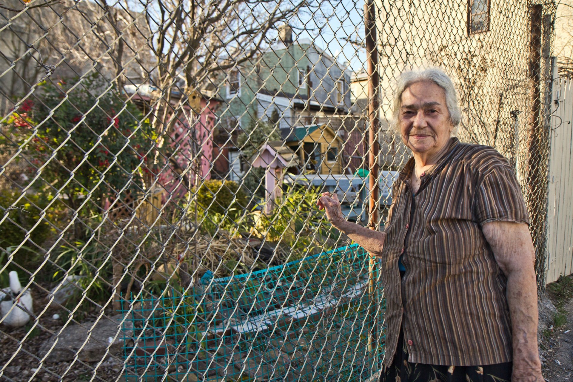 85 year-old Morgana Ginet stands in front of the lot and garden she's cultivated that could be taken away from her.