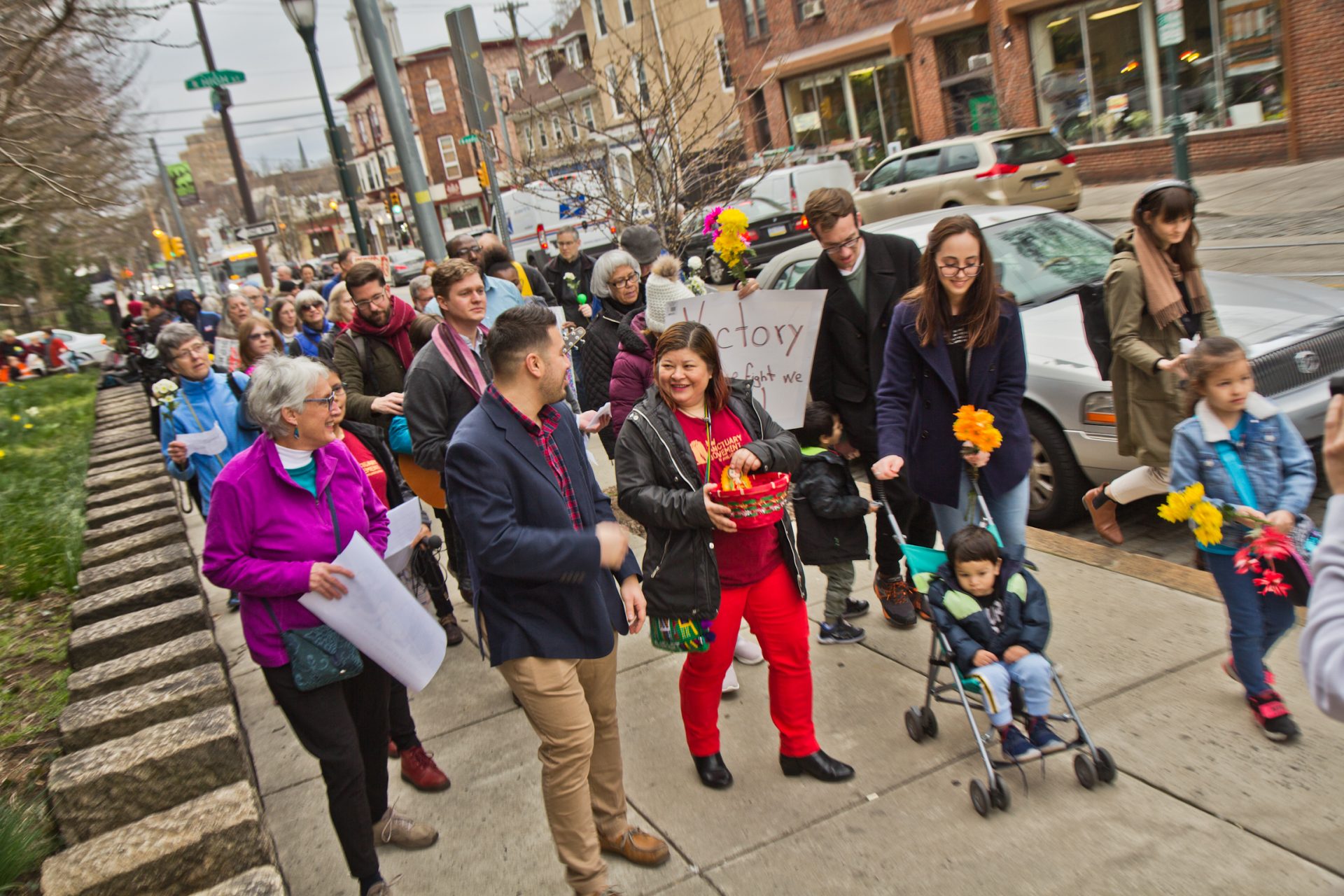 Suyapa Reyes and members of the First United congregation march to the Germantown Mennonite church where Carmela Apolonio Hernandez, another mother living in sanctuary, has called home for the past two years.