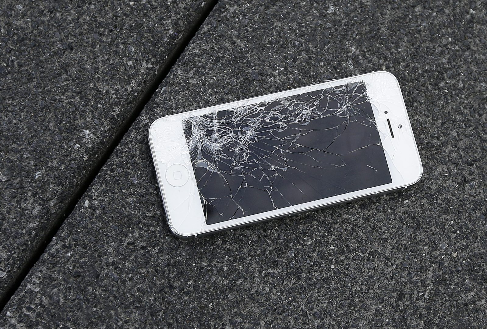 FILE PHOTO: This Aug. 26, 2015, file photo shows an Apple iPhone with a cracked screen. 