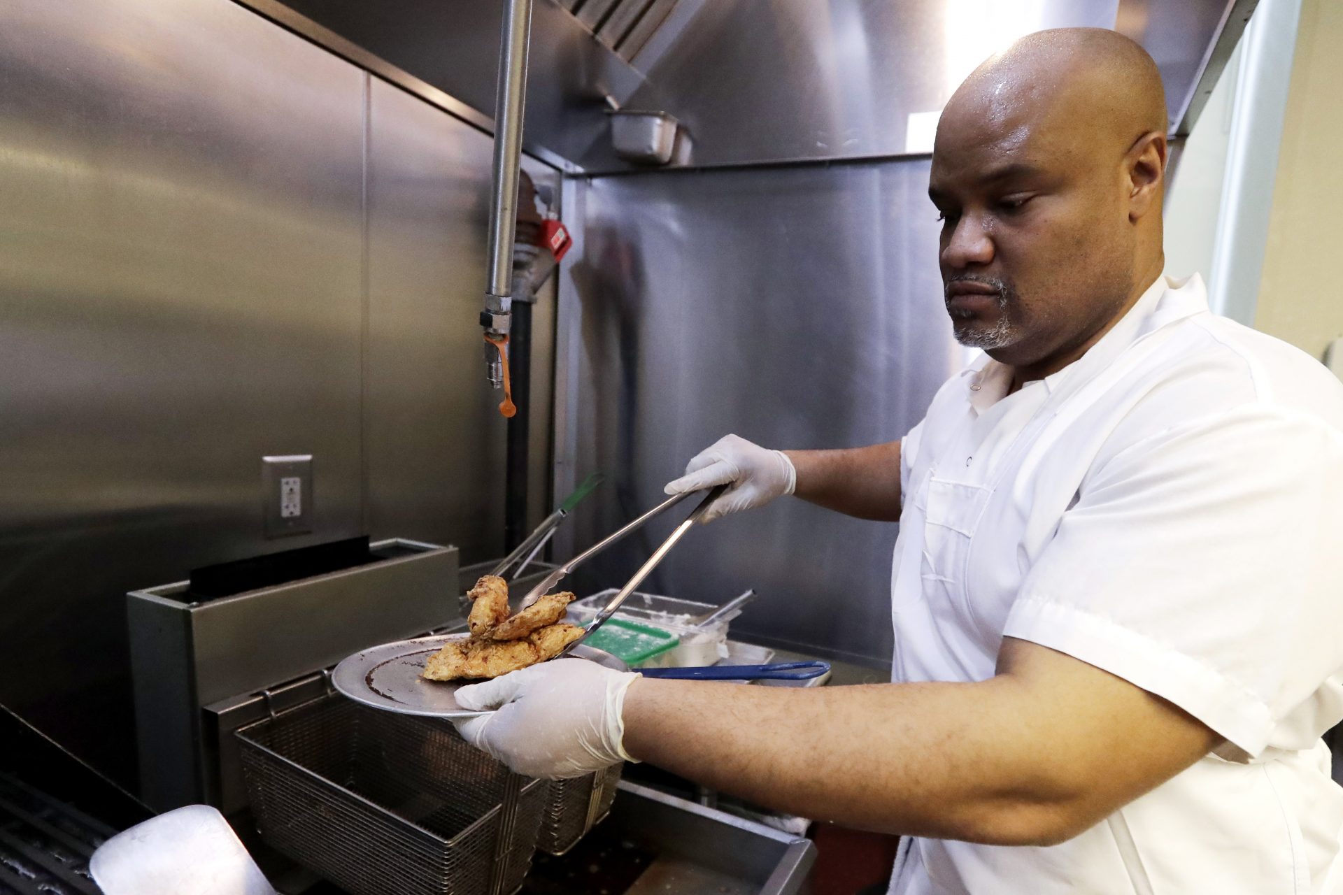 In this Jan. 29, 2020, photo, trainee Anthony Redmond works at Inspiration Kitchens in Chicago. Redmond, 44, started receiving food stamps when he was released from prison last summer. With the help, he was able to leave a halfway house and find his own place. After the training, he hopes to find employment and keep his benefits. (AP Photo/Nam Y. Huh)