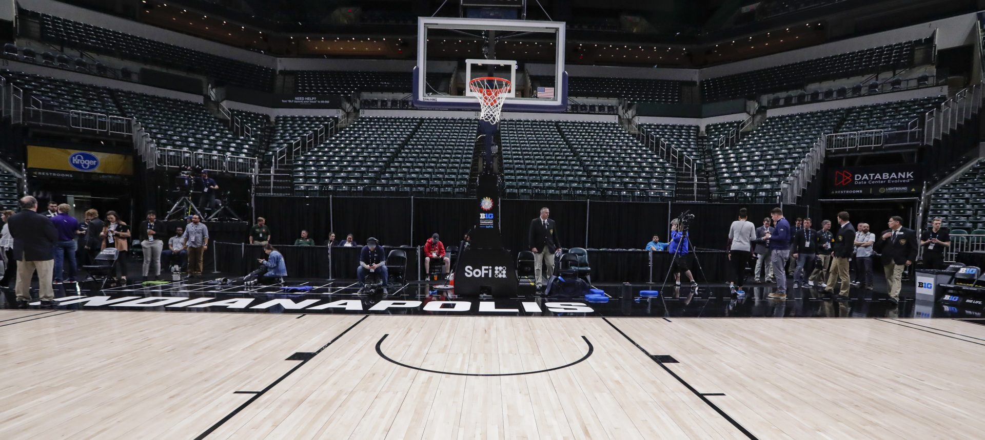 The seating area at Bankers Life Fieldhouse is empty as media and staff mill about, Thursday, March 12, 2020, in Indianapolis, after the Big Ten Conference announced that remainder of the men's NCAA college basketball games tournament was cancelled.