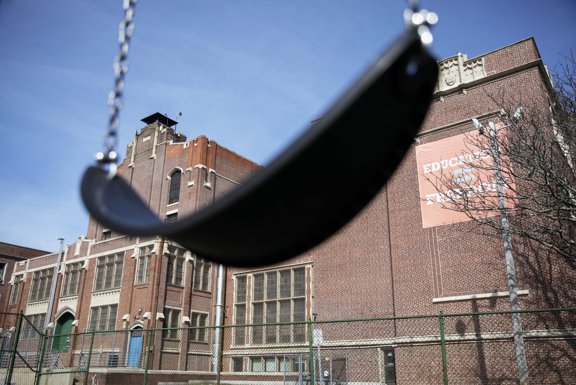 In this March 7, 2020 file photo, a swing sits empty on a playground outside Achievement First charter school in Providence, R.I. The public charter school, like a nearby Catholic school, closed after a teacher who attended the same Italy trip awaited test results for the new coronavirus. Many parents are now deciding how to talk to their children about the virus.