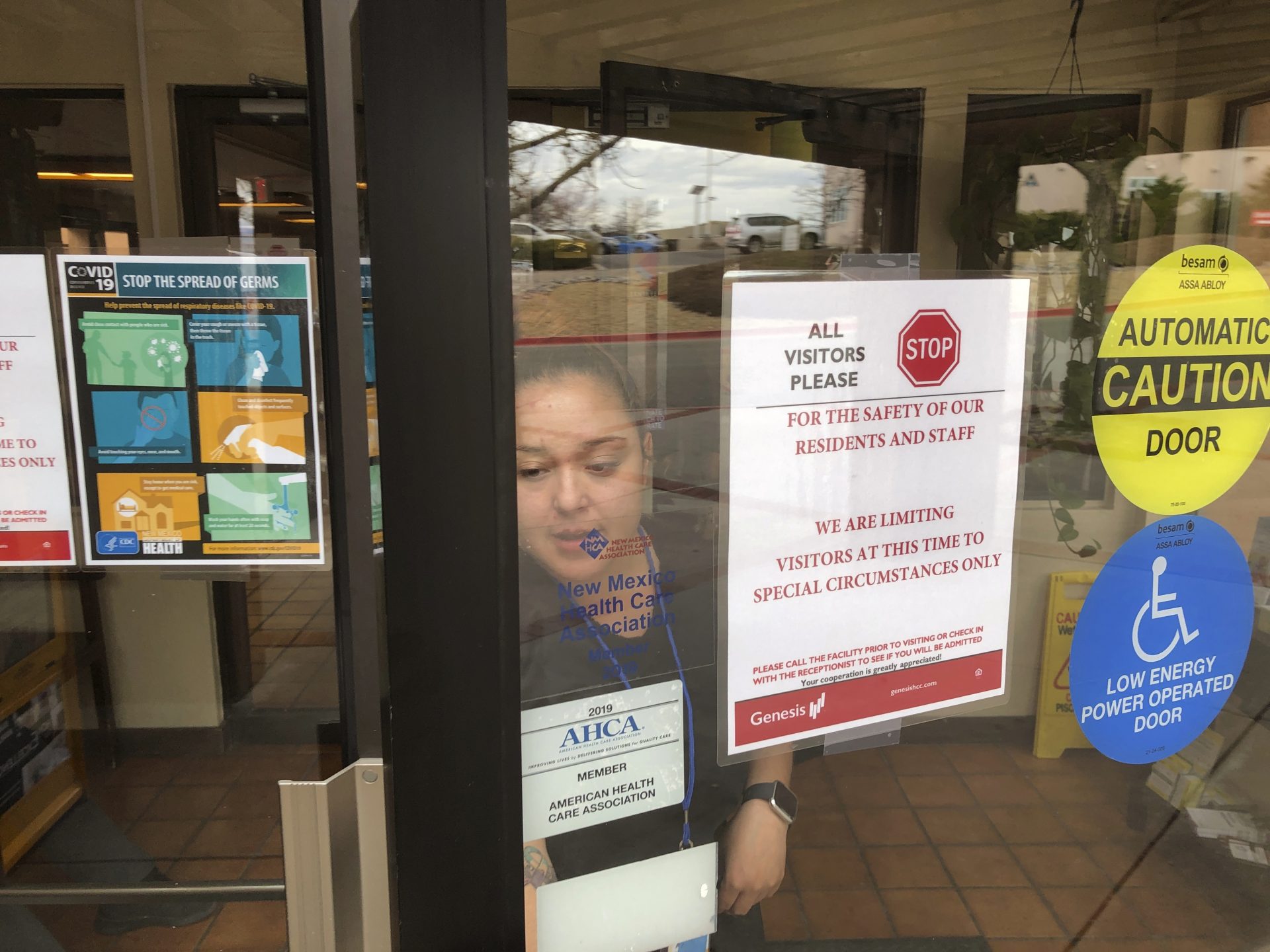 Government-mandated warning signs regarding the coronavirus greet visitors at a nursing home and rehabilitation center for the elderly Thursday, March 12, 2020, in Santa Fe, N.M.