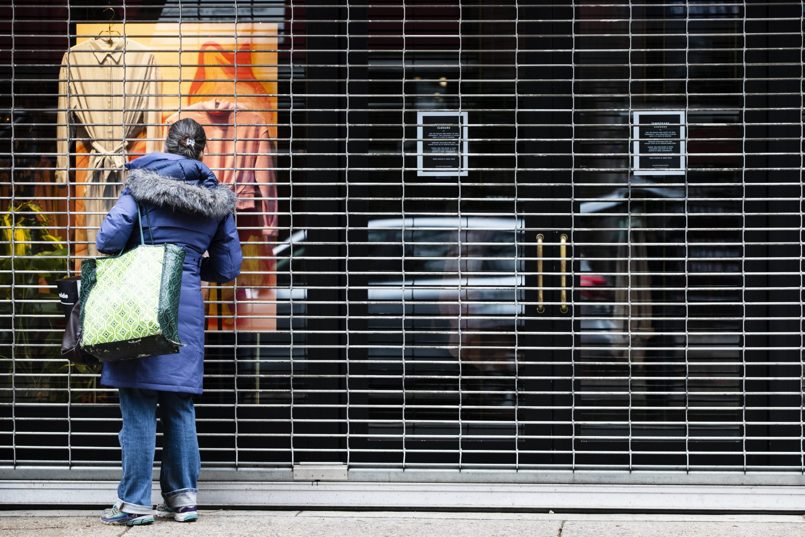 A person window shops at an temporary closed business in Philadelphia, Thursday, March 19, 2020. (AP Photo/Matt Rourke)