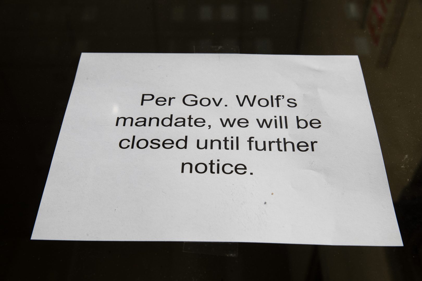 A sign is posted in the window of a closed business in Philadelphia, Friday, March 20, 2020. Gov. Tom Wolf directed all 