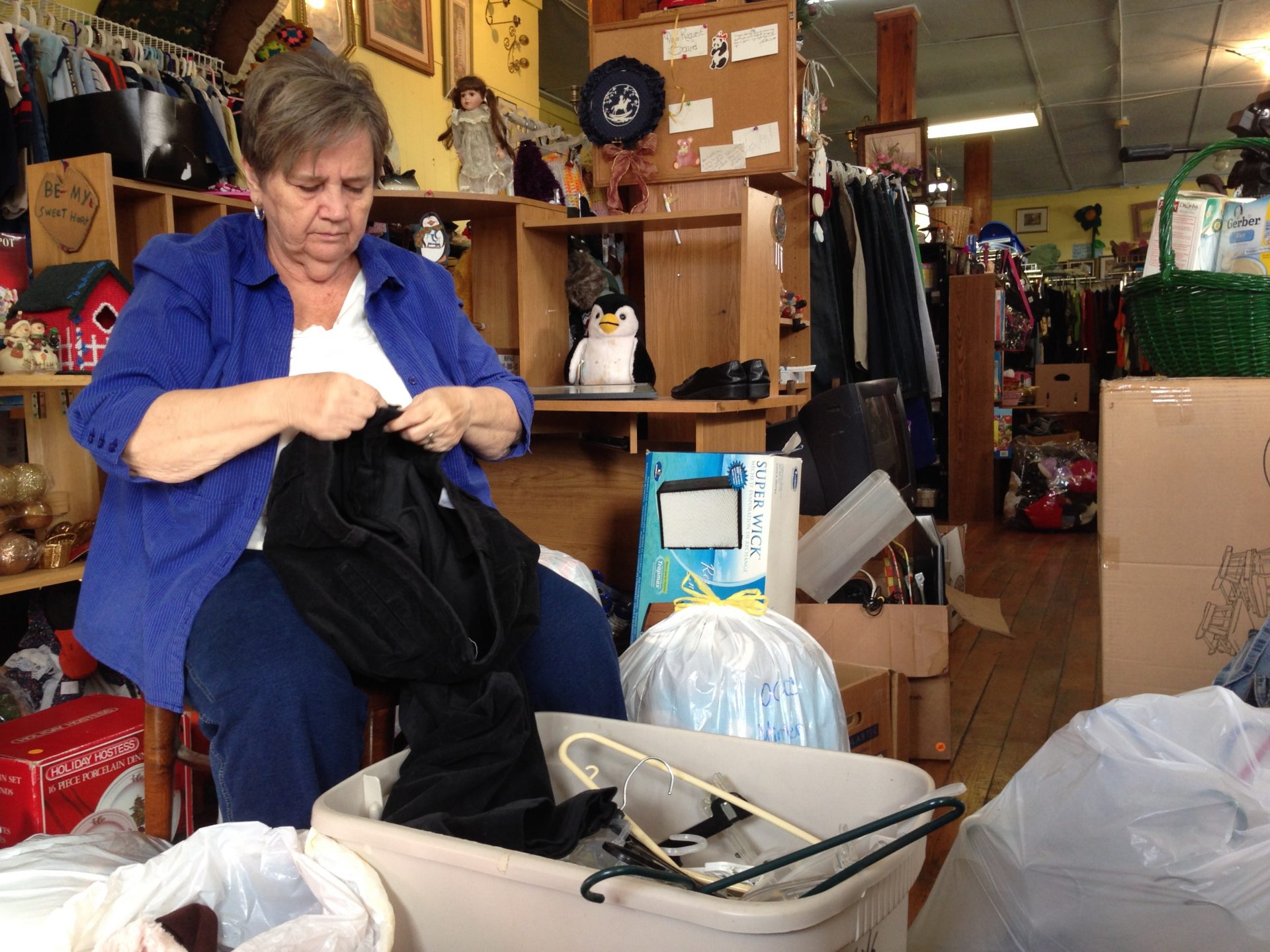 FILE PHOTO: In this Nov. 21, 2013 photo, Cleda Turner, director of the Owsley County Outreach, folds clothes at the thrift store in Booneville, Ky. A drop in federal food assistance has struck Owsley County hard.