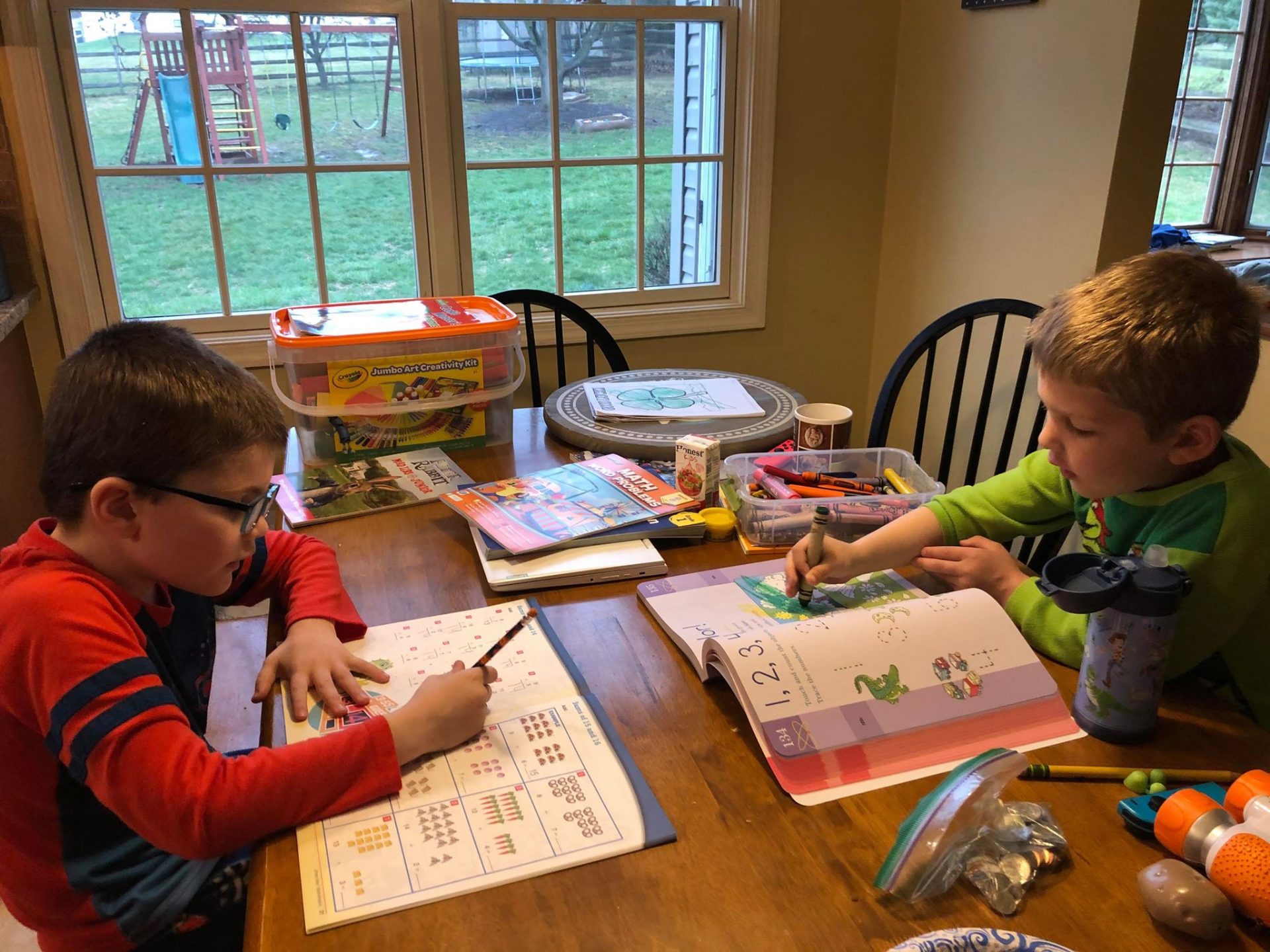 Tara Ryan-Schill's sons Andrew, left, and Luke, right, doing schoolwork at home. Andrew is an 8-year-old on the autism spectrum.