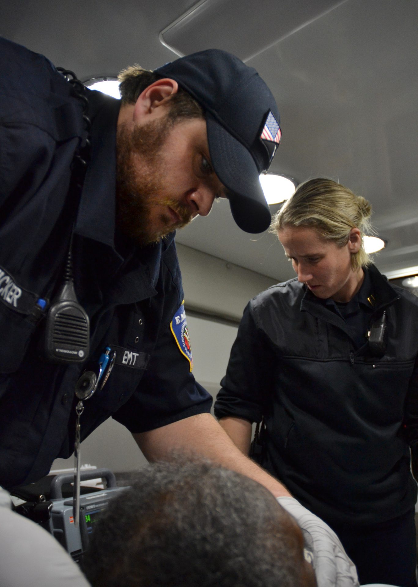 Emergency medical technician Brandon Eicker places a mask on a nursing home patient as she is transported to a hospital in Harrisburg, Pennsylvania. At right is paramedic Julia Hanson. 
