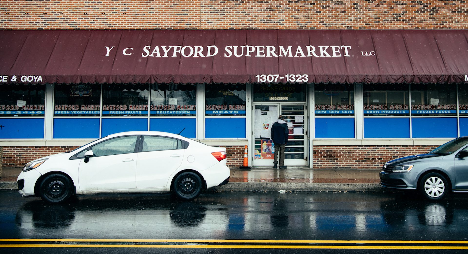 At the Sayford Market in Harrisburg, an employee tells a customer through the glass that they’re closed for the day.