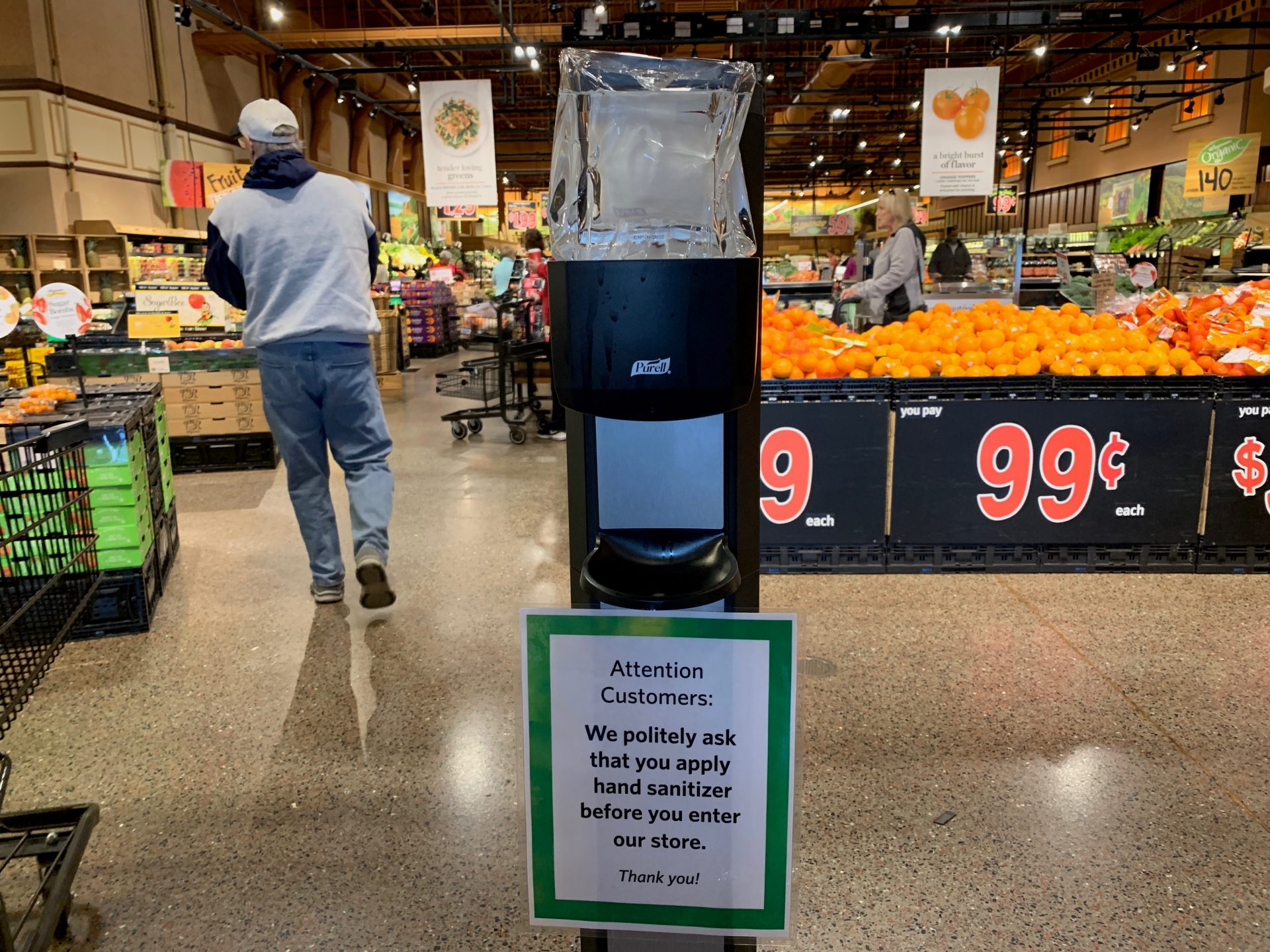A sign near the entrance to Wegmans in Mechanicsburg, Pa., asks customers to sanitize their hands before shopping on March 14, 2020. The first COVID-19 cases in the county were announced the day prior.