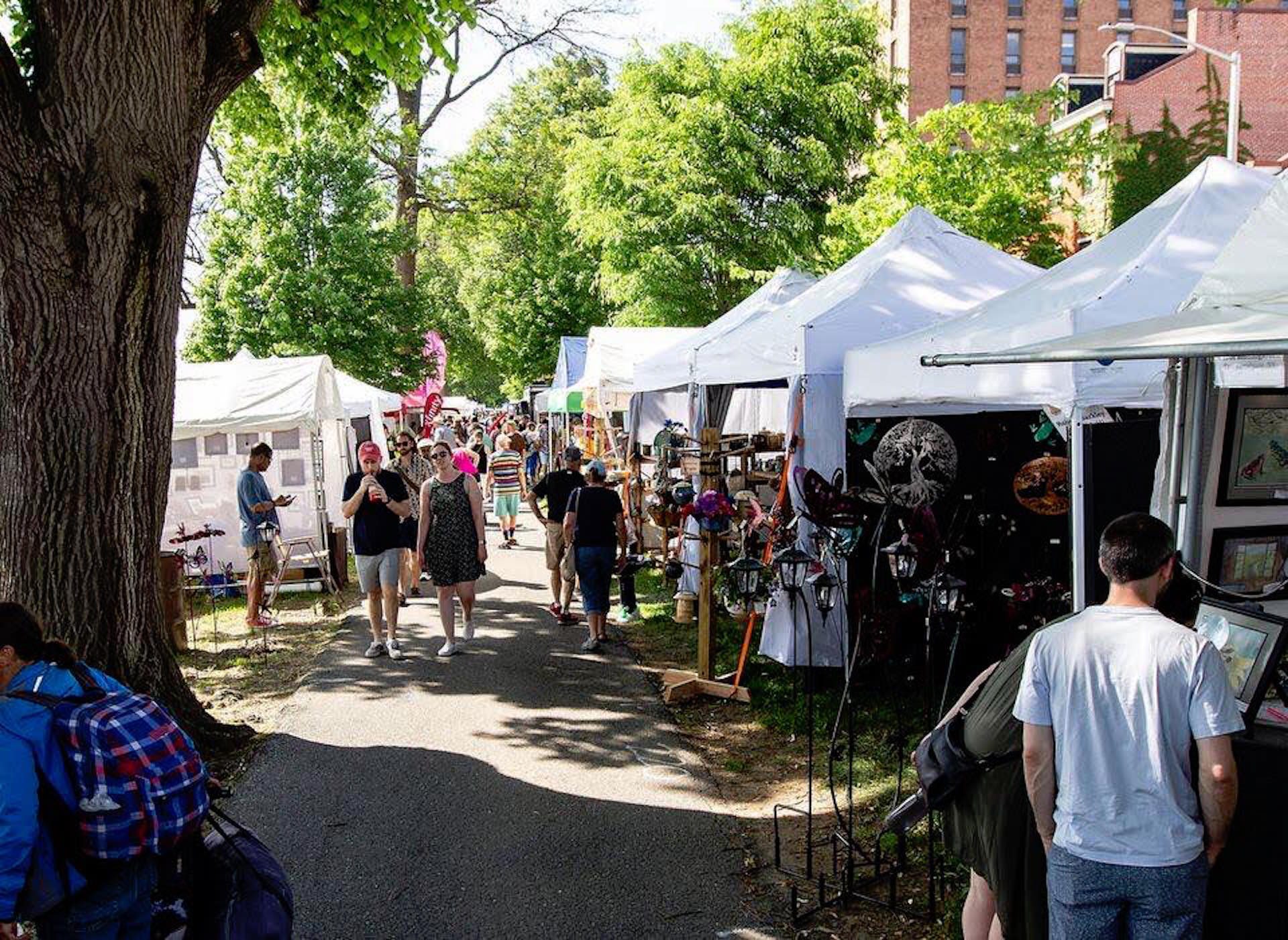 People walk along the sidewalk in Riverfront Park during Artsfest of Greater Harrisburg in 2018.