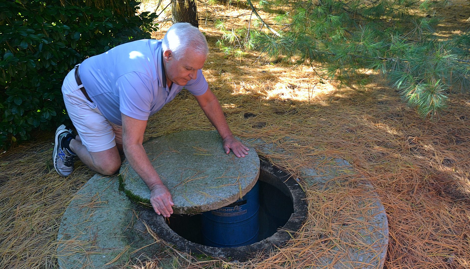 Jerry Solomon, of West Lampeter Township, rolls the stone slab that covers his private well water pump at the back of his home on Dec. 9, 2019. Solomon's well was tested three times, the first time the results showed nitrate levels more than two limes the Environmental Protection Agency maximum limits for public drinking water systems.
