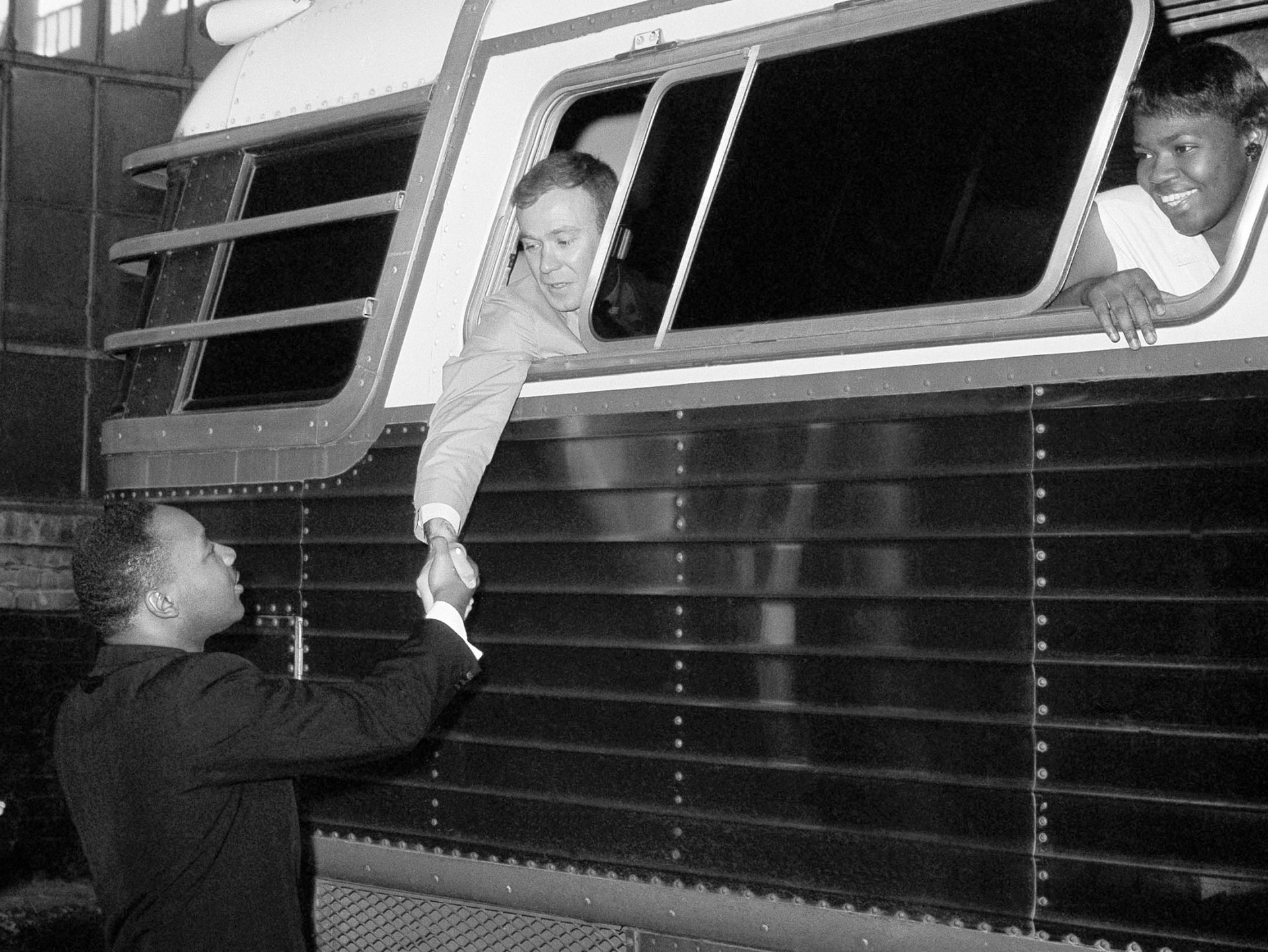 Dr. Martin Luther King Jr., civil rights leader, shakes hands with Paul Dietrich just before a bus of Freedom Riders left Montgomery, Ala., May 24, 1961.