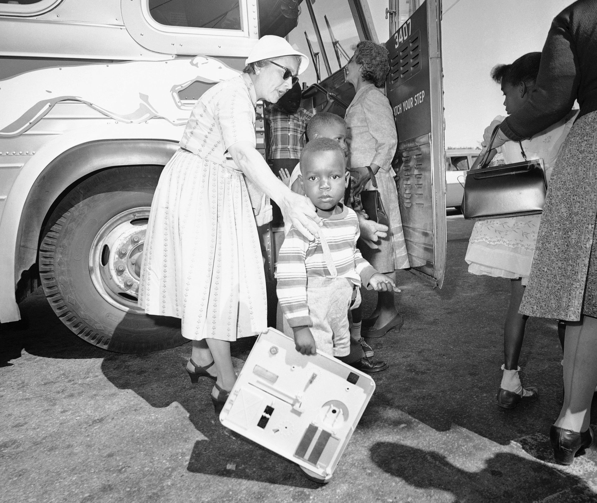 Two unidentified women, residents of Hyannis, Mass., help some of the nine children of Lela Mae Williams (not in photo) off the bus, June 8, 1962 at Hyannis on their arrival from Huttig, Ark.