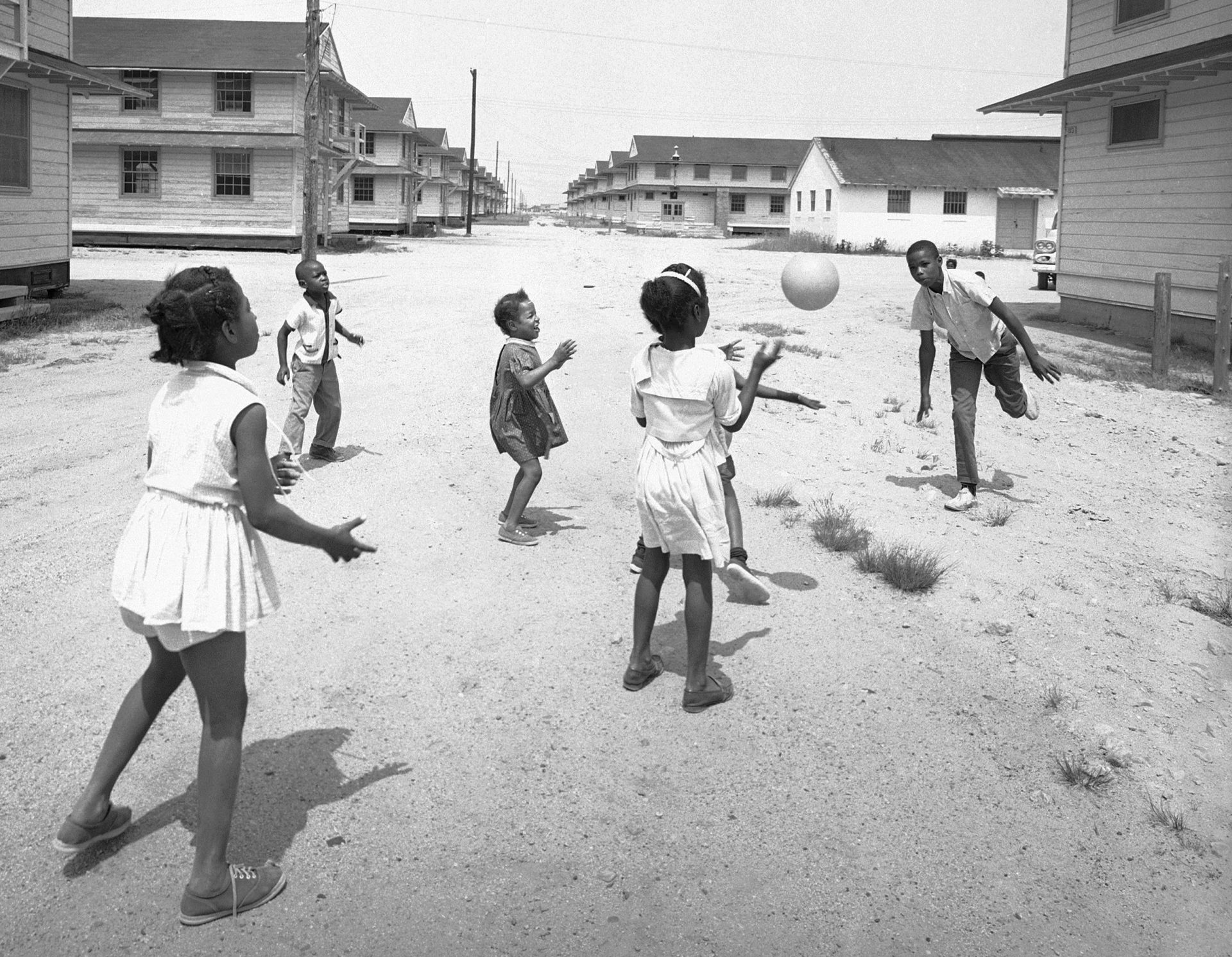 Some children of reverse freedom riders families toss ball among themselves amid Army barracks at Camp Edwards, Mass., June 11, 1962.