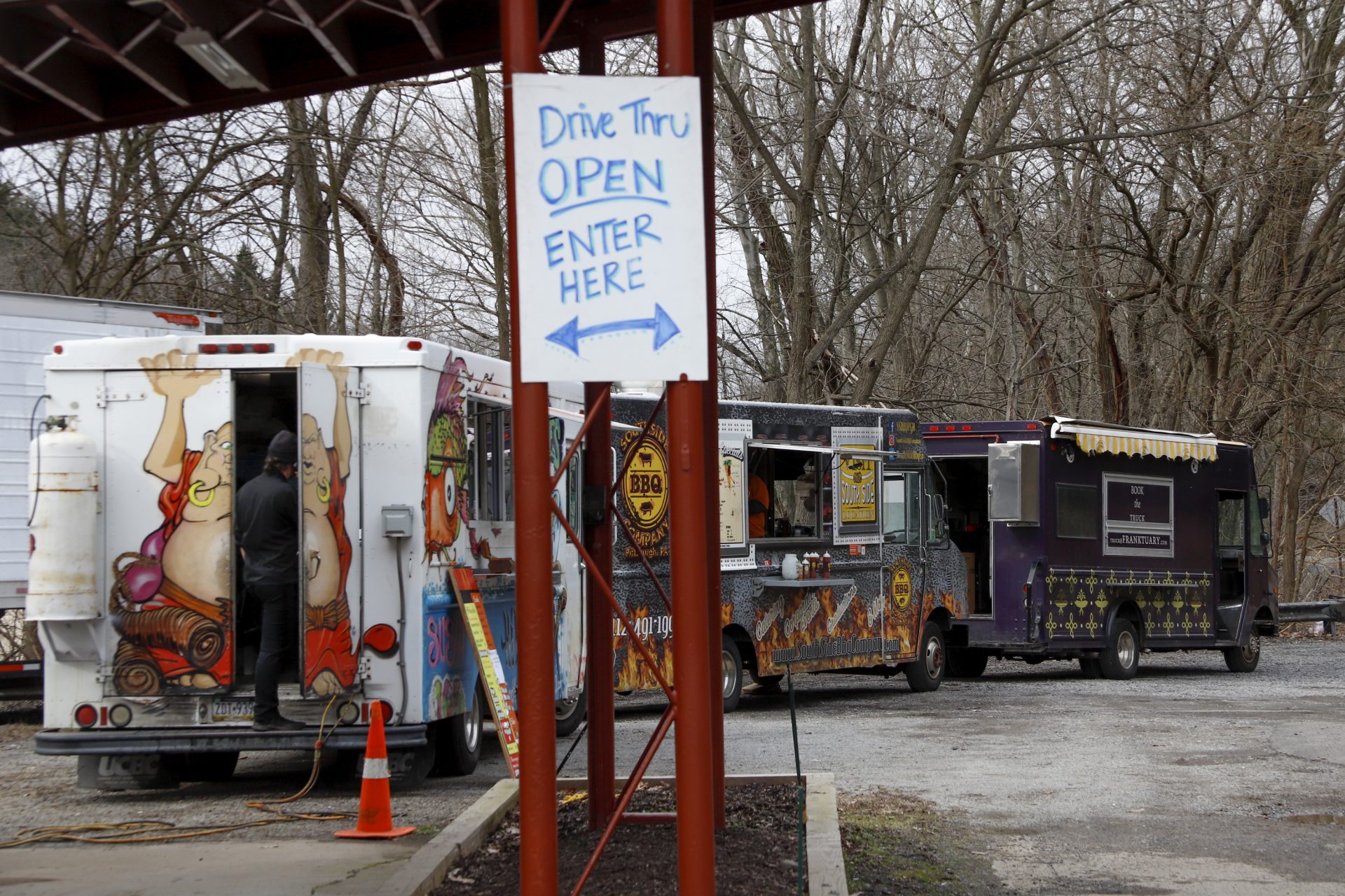Three food trucks line up in a lot for people to buy take out dinners, Thursday, March 19, 2020, in the Ross Township suburb of Pittsburgh. They we giving people an option since restaurants with indoor dining areas are closed in efforts to slow the spread of COVID-19.