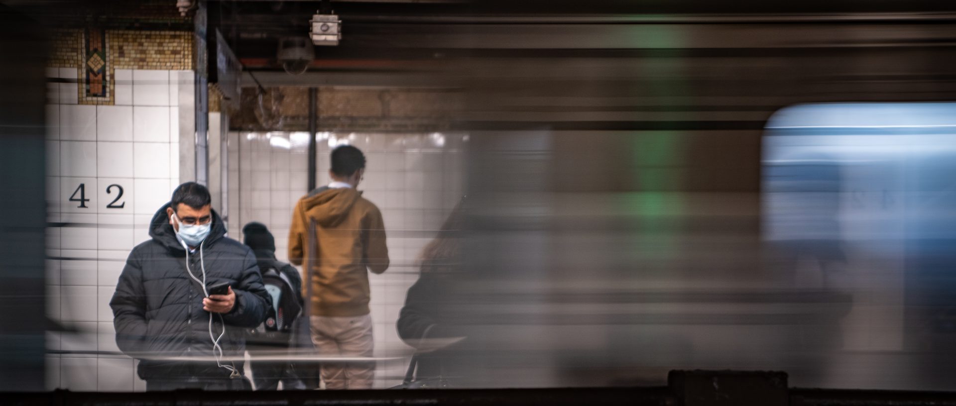 A commuter wearing a medical mask waits for a train Thursday at Grand Central station in New York City. Several dozen cases have been confirmed in the state, and the East Coast as a whole saw its first two confirmed deaths related to COVID-19, in Florida.