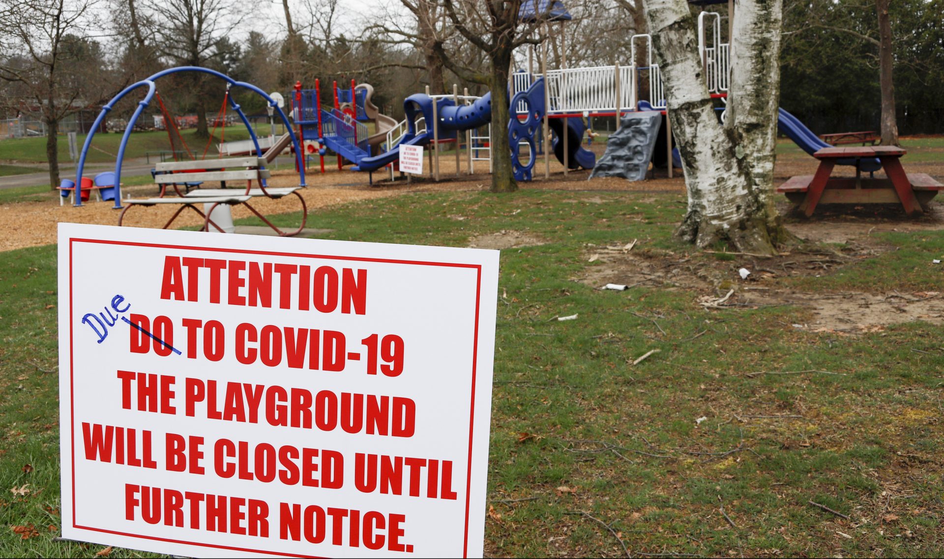 A sign with corrected spelling, tells visitors the playground at the Community Park is closed until further notice due to COVID-19, Friday, March 27, 2020, in Zelienople, Pa. The new coronavirus causes mild or moderate symptoms for most people, but for some, especially older adults and people with existing health problems, it can cause more severe illness or death.