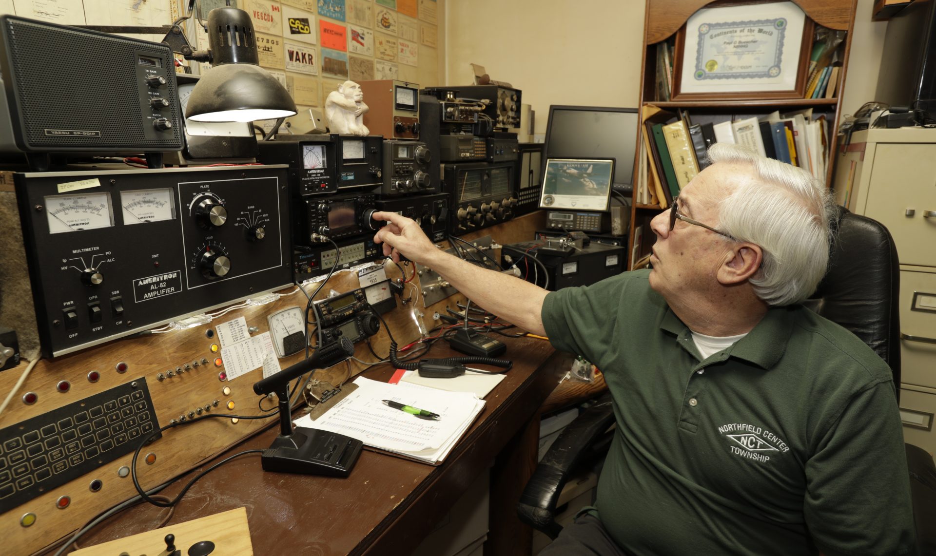 In this Friday, March 13, 2020 photo, Paul Buescher adjusts his ham radio, in Northfield Center Township, Ohio. Buescher is one of 32 members of a group in northeastern Ohio that shares a farm packed with enough canned and dehydrated food and water to last for years. For those in the often-mocked "prepper" community, this is quickly becoming their "I told you so" moment, as panic buying has cleared store shelves across the U.S. amid growing fears that the new coronavirus will force many Americans to self-quarantine for weeks in their homes.
