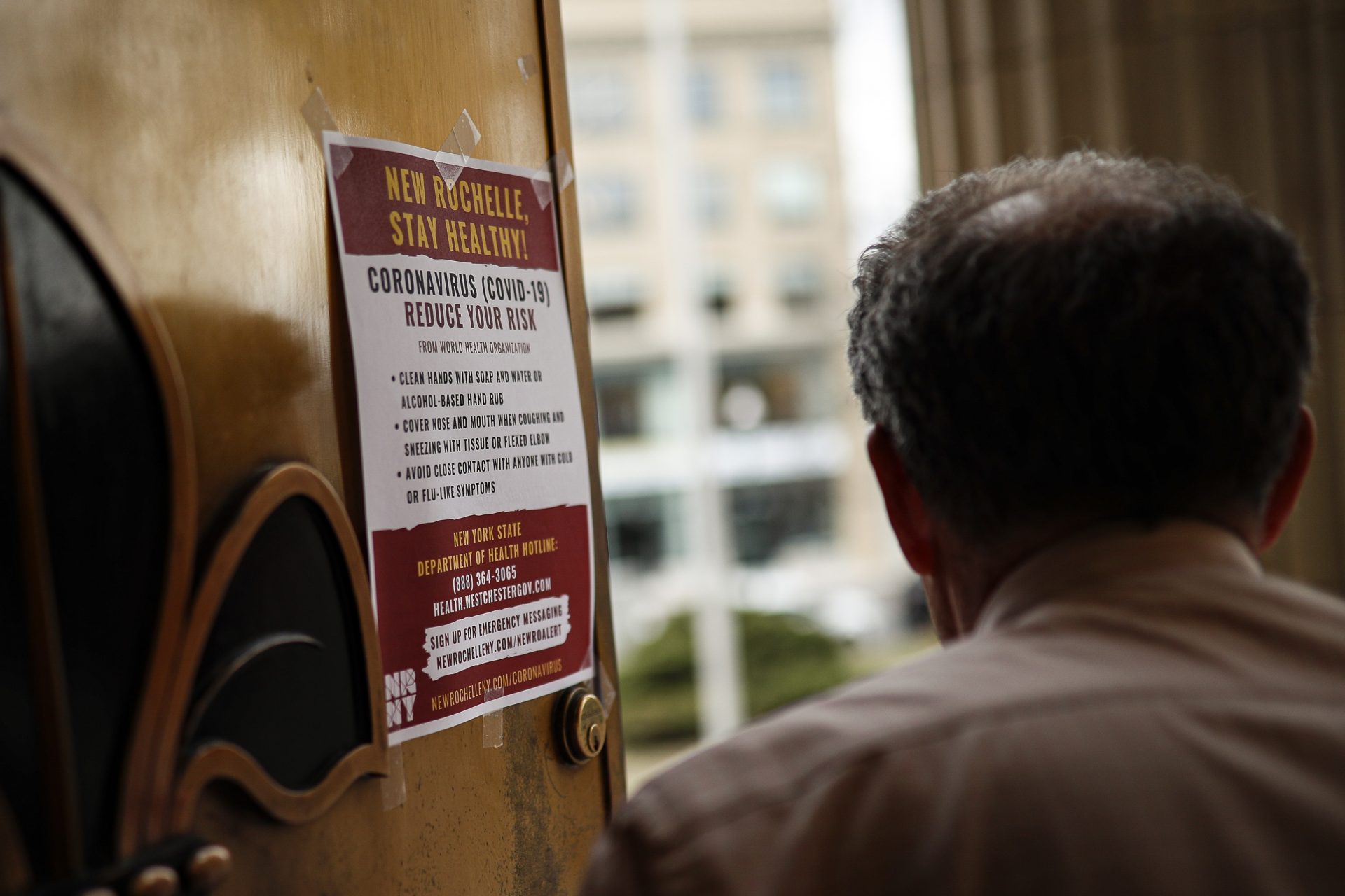 A sign providing instructions on how to reduce the risk of contracting or spreading COVID-19 is hung on the front door of New Rochelle City Hall, Tuesday, March 10, 2020, in New Rochelle, N.Y. State officials are shuttering schools and houses of worship for two weeks in part of the New York City suburb New Rochelle and sending the National Guard there to help respond to what appears to be the nation's biggest cluster of coronavirus cases.