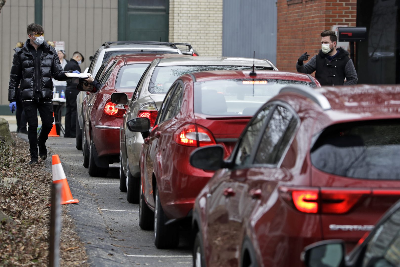 Cars line up outside the Central Outreach Wellness Center on the Northside of Pittsburgh, Monday, March 16, 2020, for drive-by testing for COVID-19. The testing, that is limited to 100 kits at present, is being done in partnership with Quest Diagnostics, one of the commercial laboratory companies that have offered COVID-19 tests to dramatically increase the nation's capability. Central Outreach Medical Director Dr. Stacy Lane said the drive-by testing is being used to not contaminate waiting rooms. The testing is based on screening questions for symptoms of dry cough or fever, Central Outreach said.