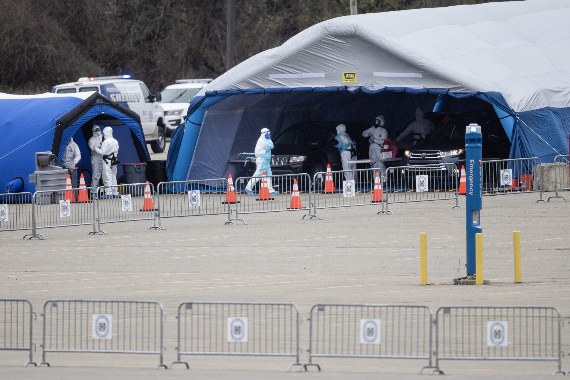 Medical workers perform coronavirus tests on drivers at the Temple University Ambler campus in Ambler, Pa., Wednesday, March 25, 2020.