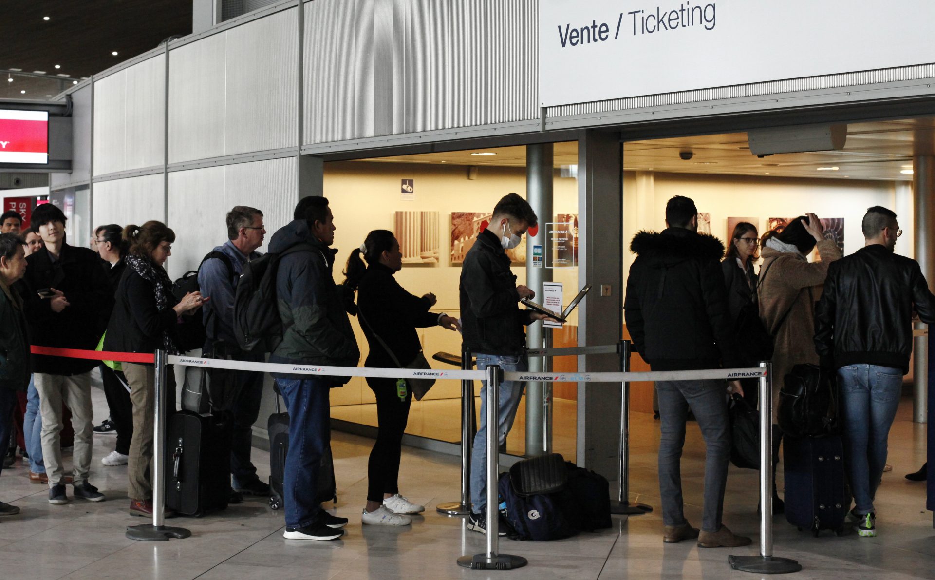 Passengers wait in front of the Air France desk at an airport near Paris on Thursday, a day after President Trump announced a 30-day ban on travel from most of Europe to the United States.