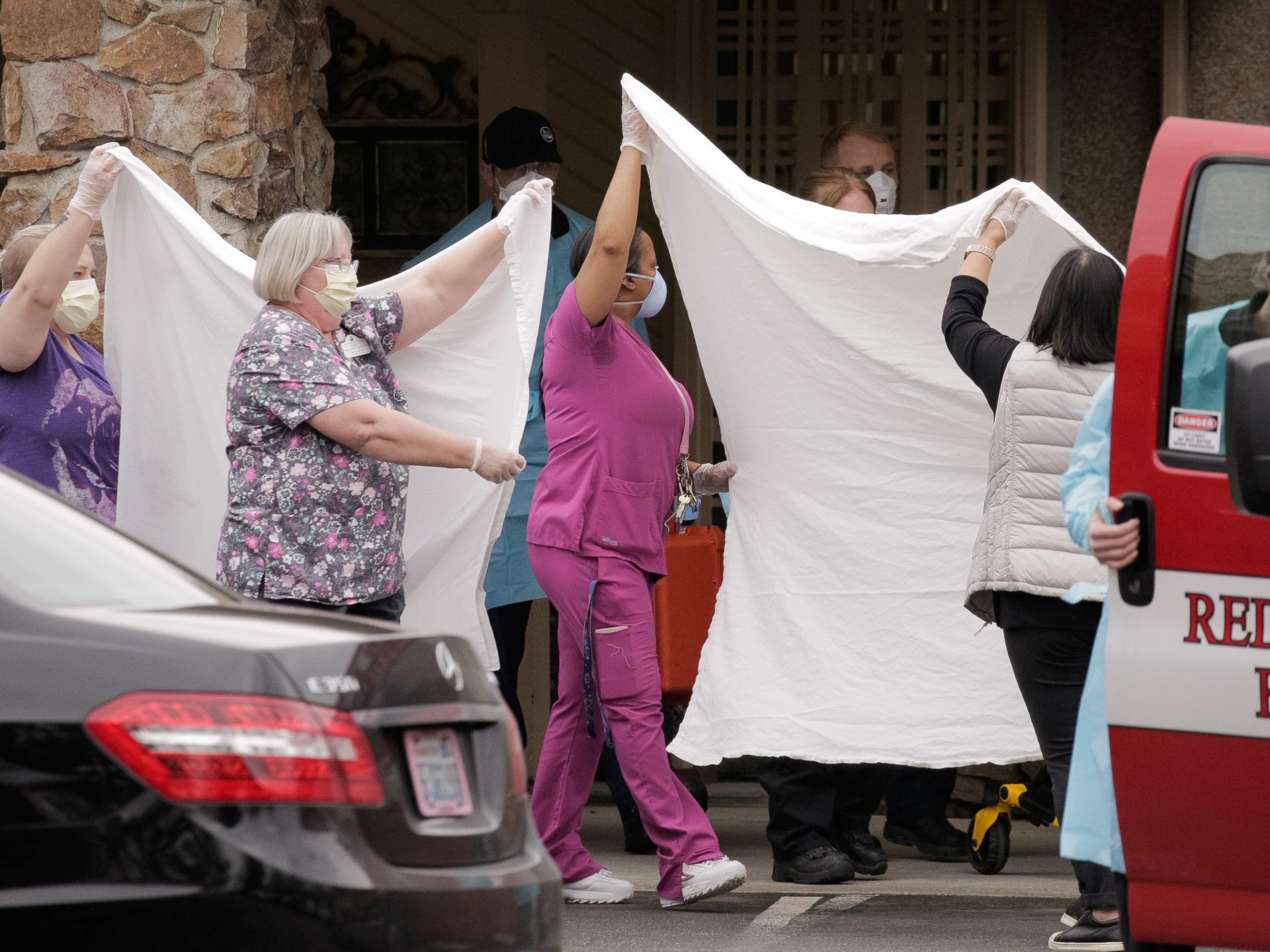 Health care workers transfer a patient to an ambulance at the Life Care Center of Kirkland, Wash., the long-term care facility where the two people who had posthumous diagnoses of COVID-19 had lived.