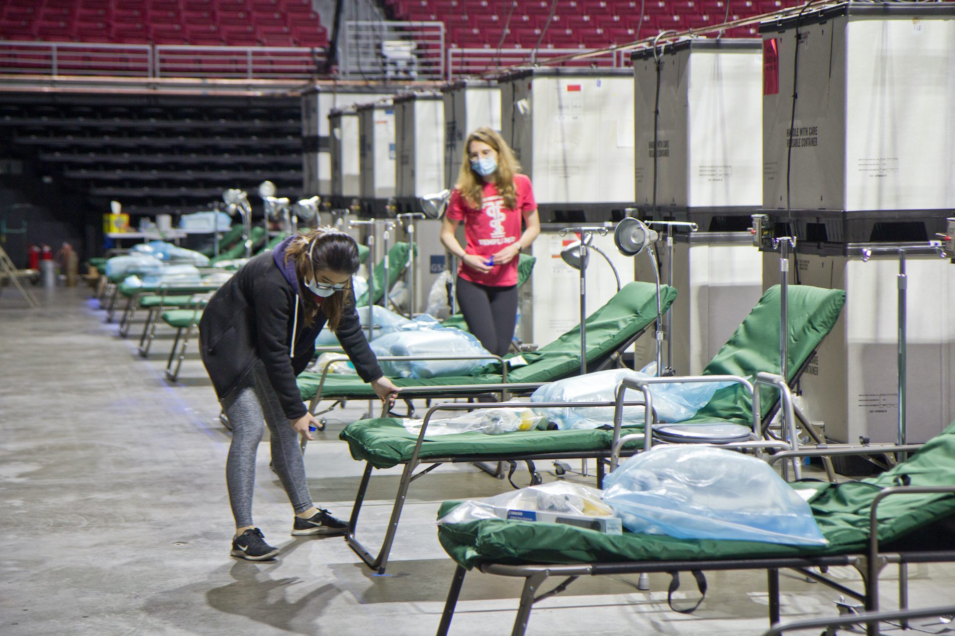 Temple University medical students work to prepare 180 beds at the Liacouras Center, which is set to open April 16 to accommodate an overflow of COVID-19 patients in Philadelphia.