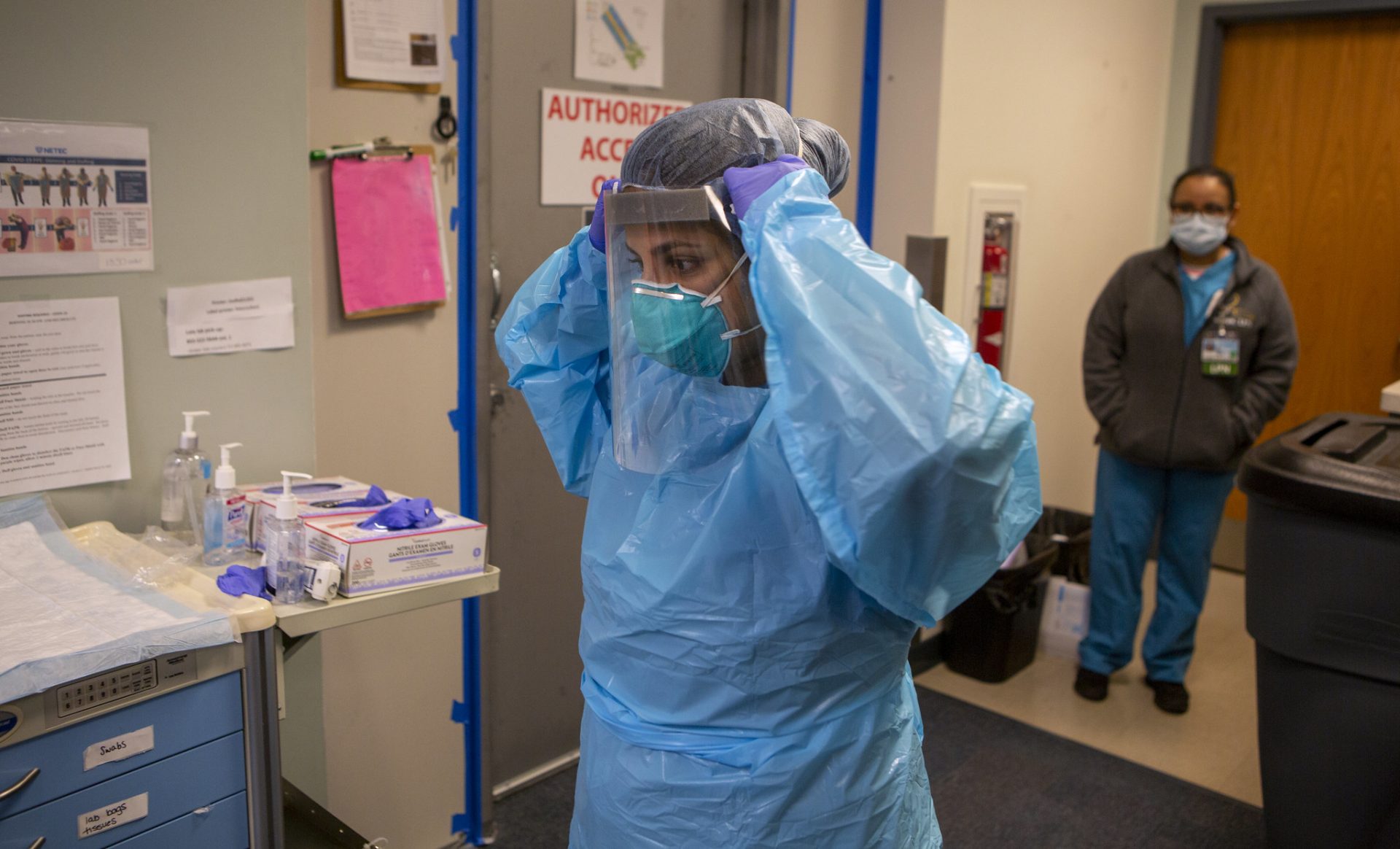 Dr. Eliana Hempel dons personal protective equipment before entering a negative pressure area to visit with a patient on Thursday, April 16, 2020. Penn State Health Medical Group has turned the West Campus Health and Wellness Center into a dedicated clinic to care for patients with confirmed or suspected COVID-19.