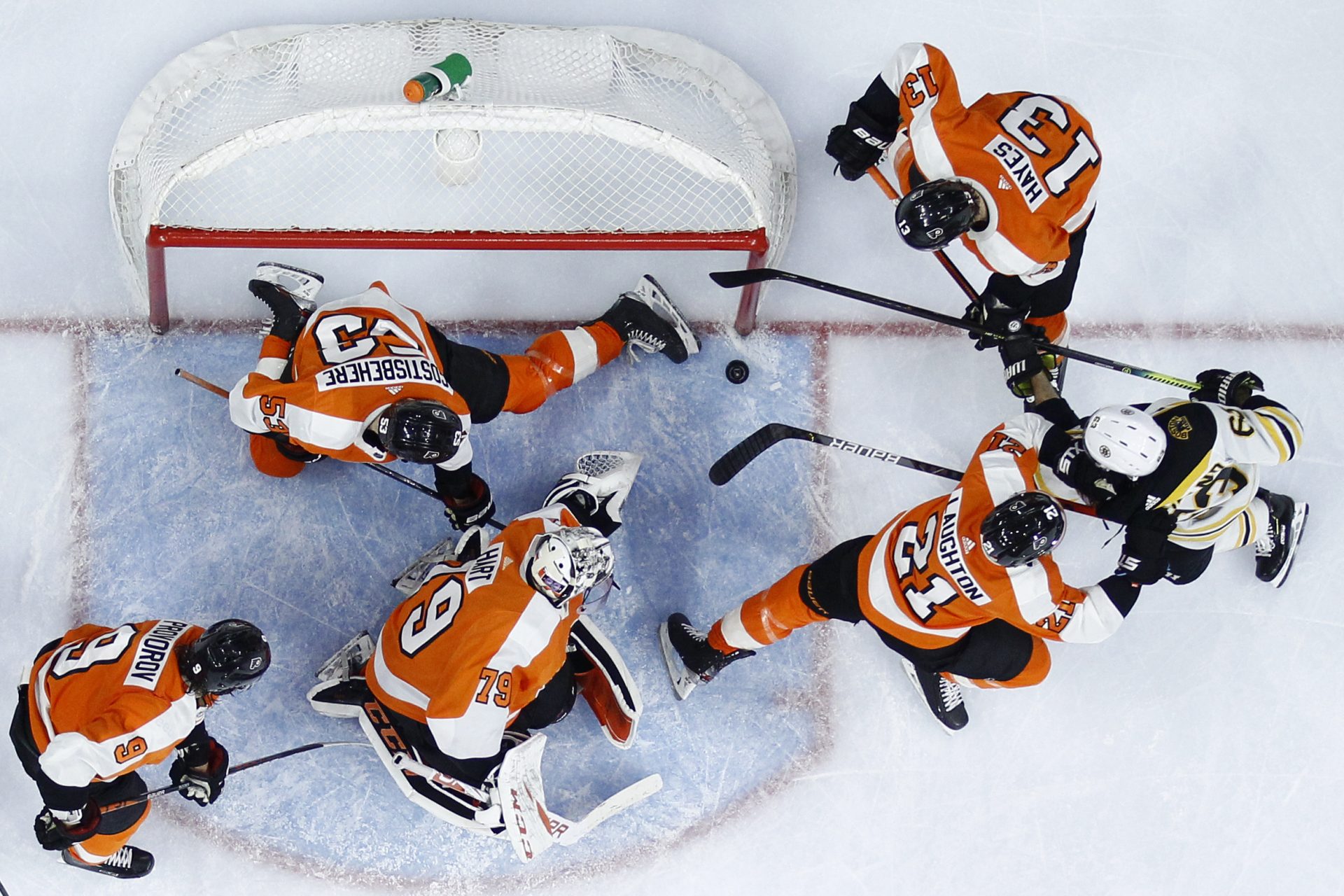 Boston Bruins' Brad Marchand (63) tries to score a goal past Philadelphia Flyers' Shayne Gostisbehere (53) as Scott Laughton (21), Kevin Hayes (13), Carter Hart (79) and Ivan Provorov (9) defend during the third period of an NHL hockey game, Tuesday, March 10, 2020, in Philadelphia.