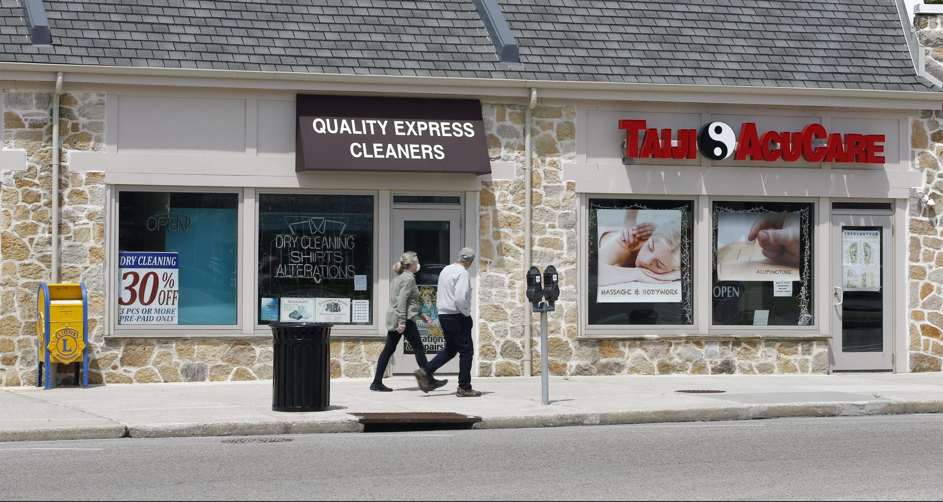 FILE PHOTO: A couple walks past a row of closed businesses, Wednesday, April 29, 2020, in Upper Darby, Pa.