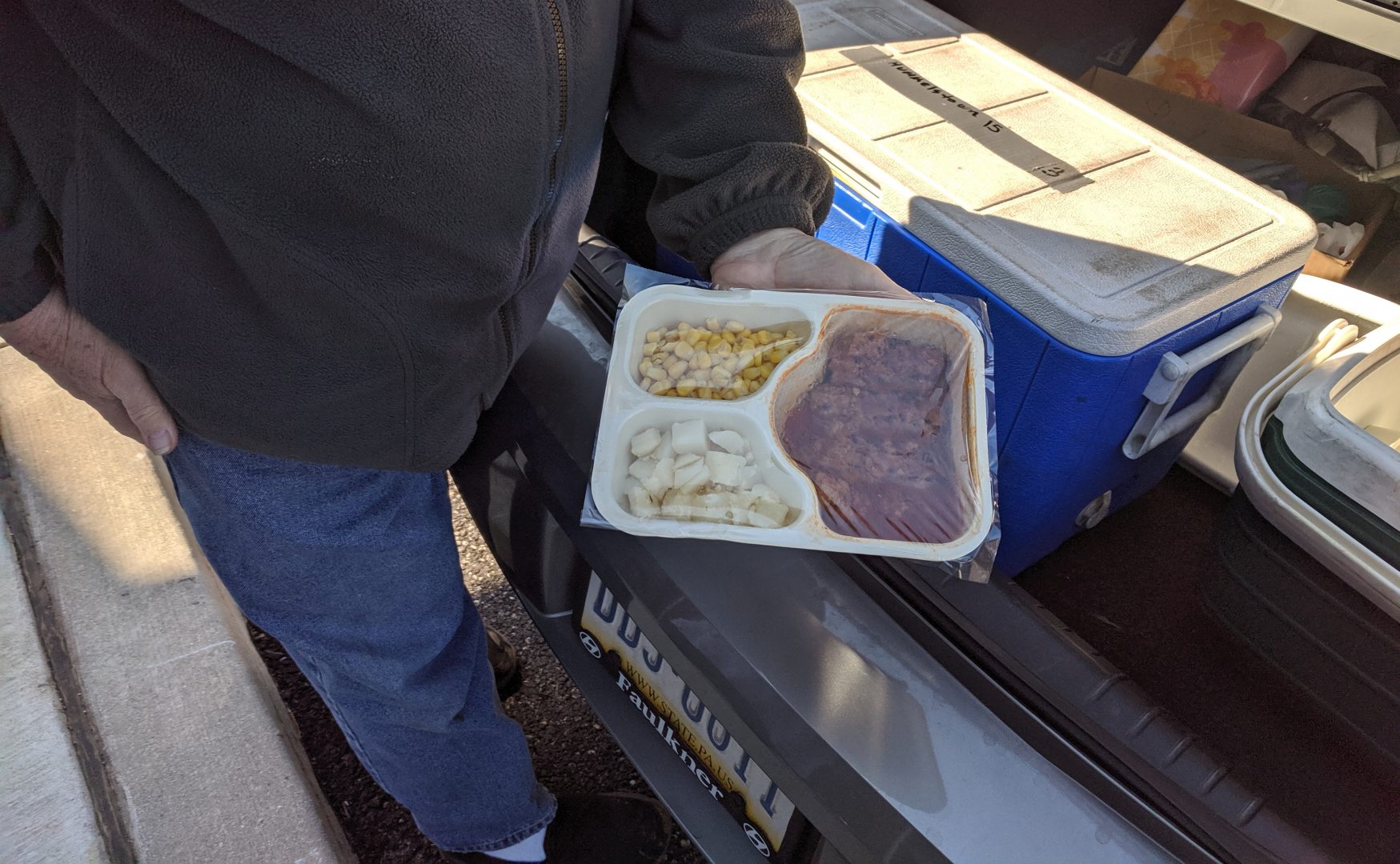 Bob Sharland holds out a meal ready to be delivered in Hummelstown, Dauphin County, on Thursday, April 2, 2020. Meals on Wheels volunteers are taking extra precautions and minimizing contact with clients to help reduce spread of COVID-19. 