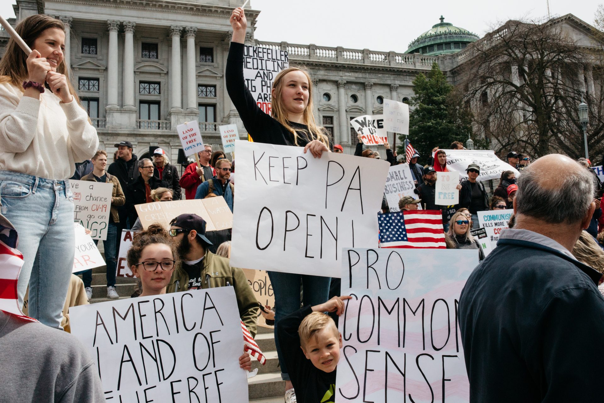 Protesters hold handmade signs outside the capitol in Harrisburg on Monday, April 20, 2020.