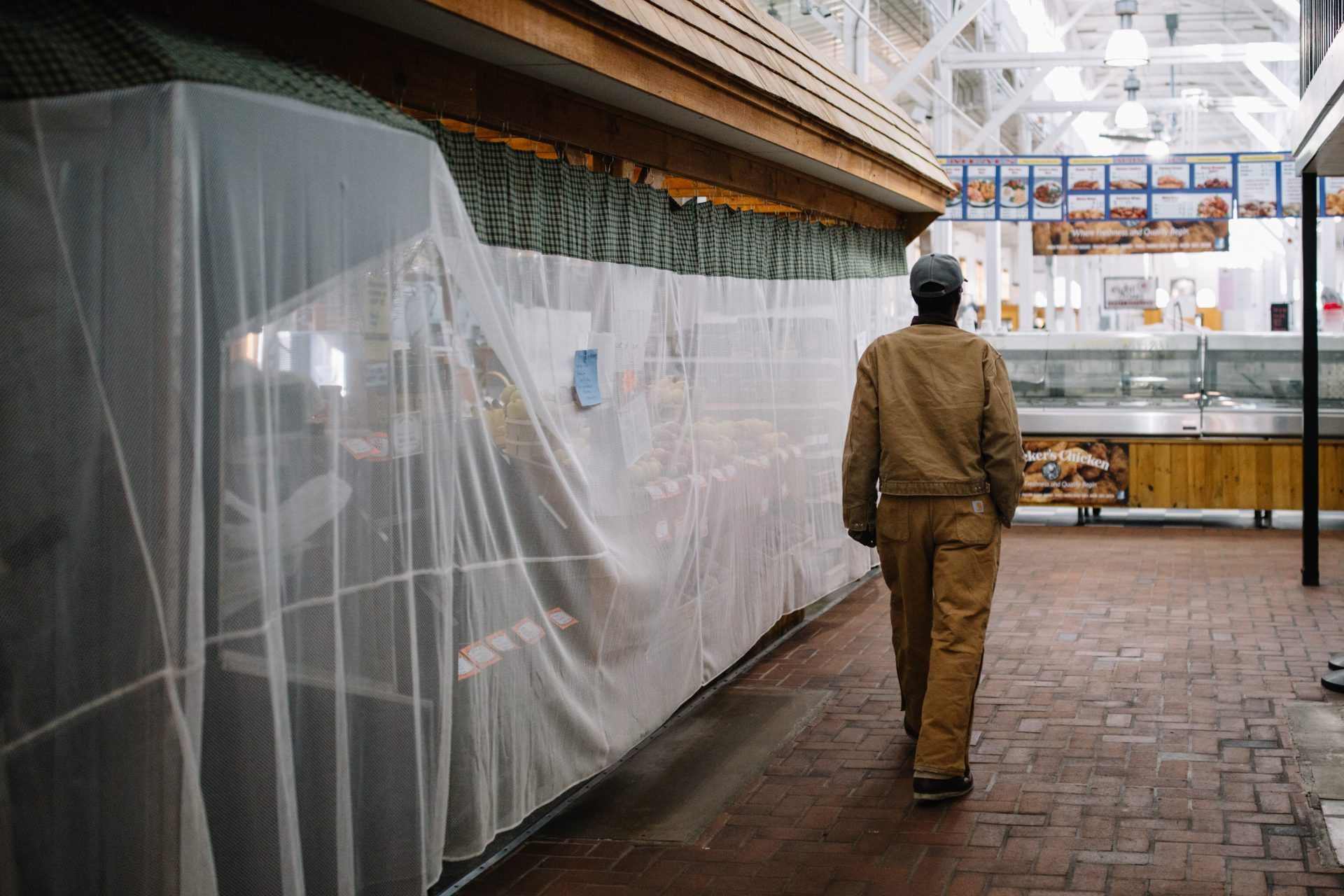 A man walks past a covered stall at Broad Street Market in Harrisburg on April 10, 2020.