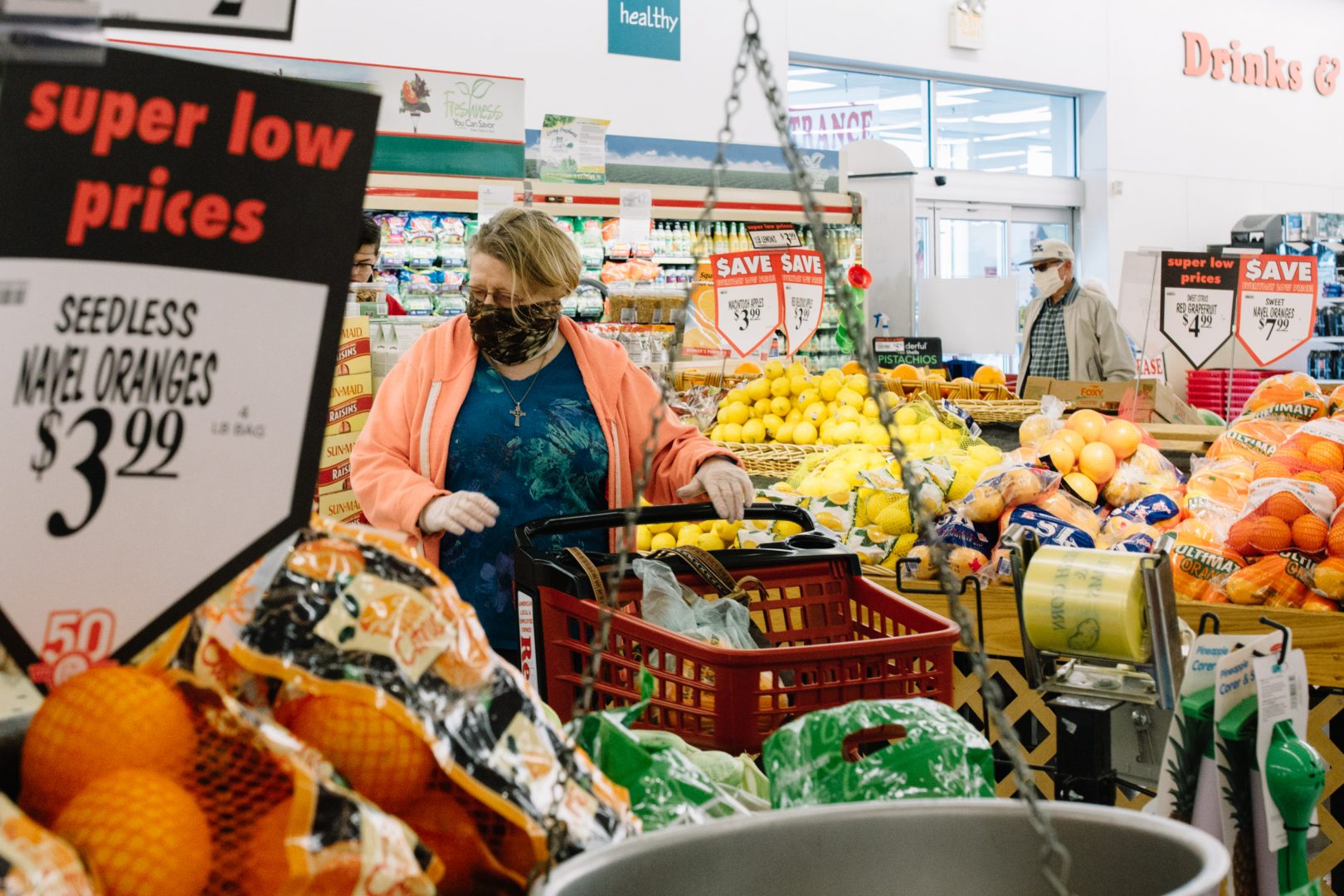 Grocery shoppers wearing masks pick out produce at a Redner's Warehouse Market on April 10, 2020.