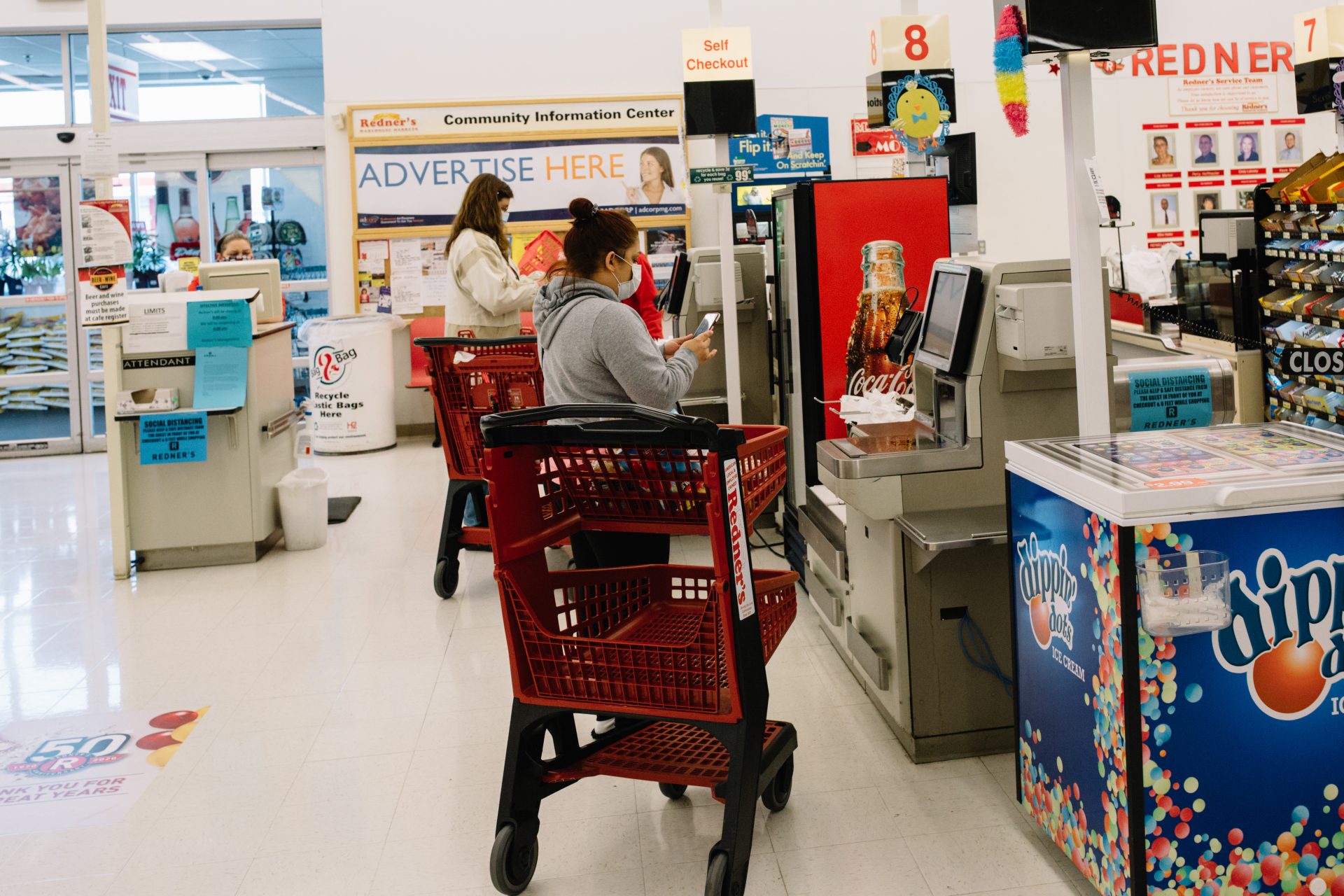 Shoppers wearing masks use the self check-out stations at a Redner's Warehouse Market on April 10, 2020.