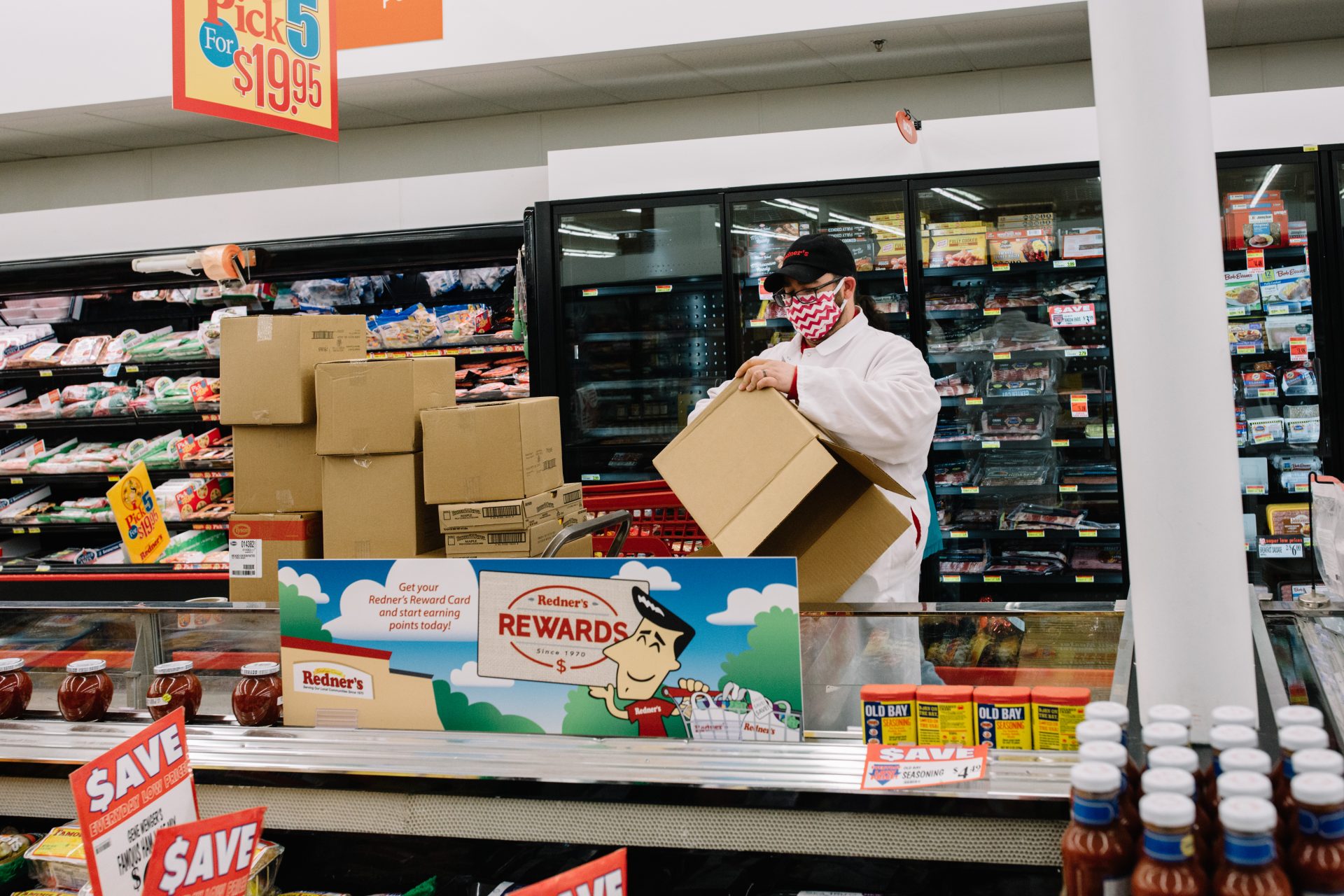 An employee wearing a mask breaks down boxes at a Redner's Warehouse Market on April 10, 2020.