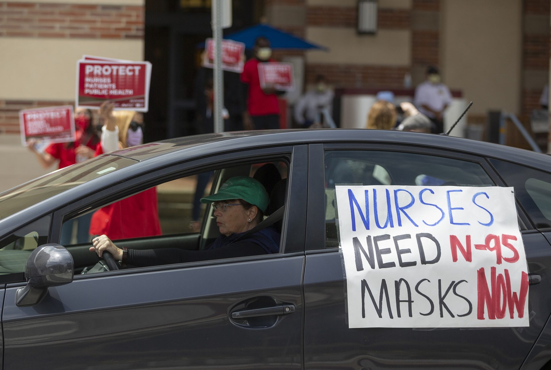 FILE - In this April 13, 2020, file photo, a car passes nurses protesting the lack of N95 respirators and other Personal Protective Equipment outside the UCLA Medical Center, Santa Monica amid the coronavirus pandemic in Santa Monica, Calif. An Associated Press review of more than 20 states found that before the coronavirus outbreak many had at least a modest supply of N95 masks, gowns, gloves and other medical equipment. But those were often well past their expiration dates â€” left over from the H1N1 influenza outbreak a decade ago.